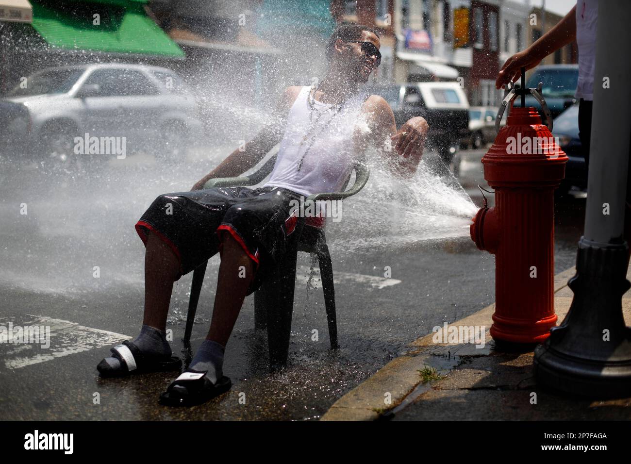 Sweating Pipe Fire A person cools off in spraying water from a fire hydrant in the ...