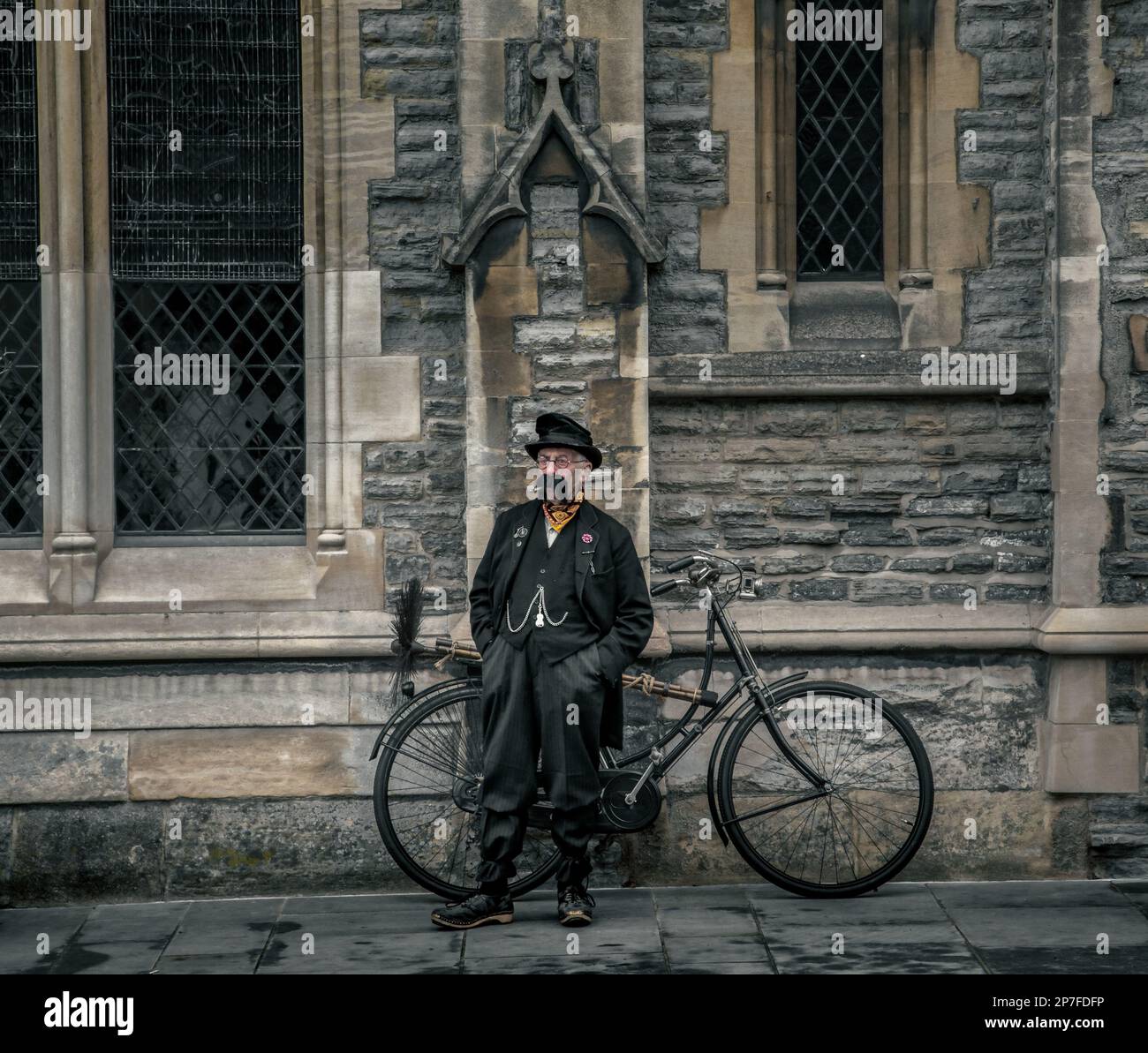 Ein viktorianischer Schornsteinfeger mit einem großen Schnurrbart, der neben seinem Fahrrad steht. Stockfoto
