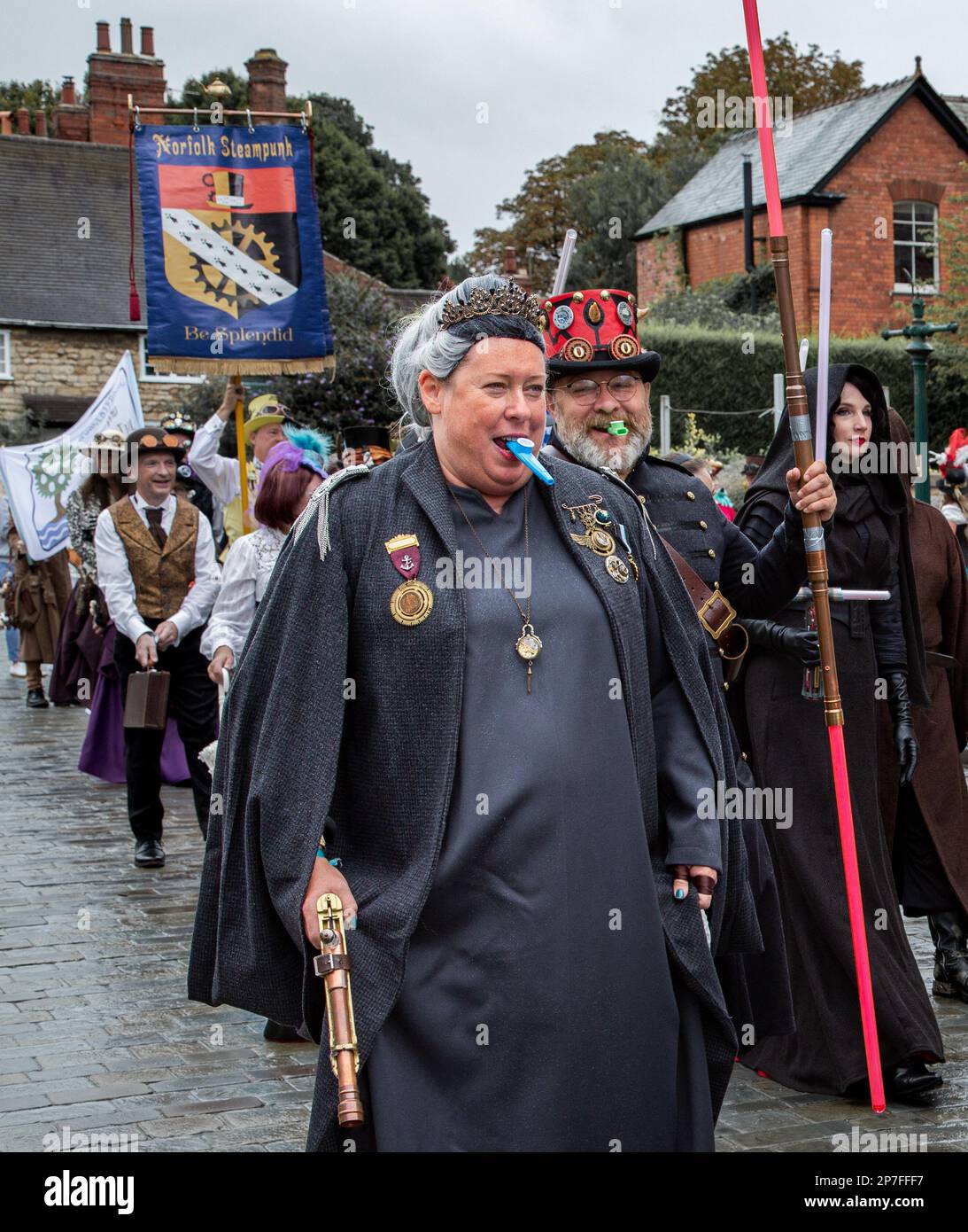 Eine Gruppe von Steampunken, die in einer Prozession entlang einer Straße laufen. Stockfoto