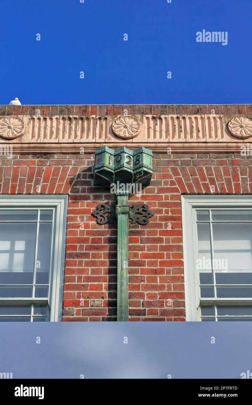 Rote Backsteinfassade aus dem Jahr 533 mit gewellten Frieze-Blütenmedaillons, rostige Dekoration des Führungskopfes, AD1928 erbautes Gebäude im Vorort Corso-Manly. Sydney-AUS. Stockfoto