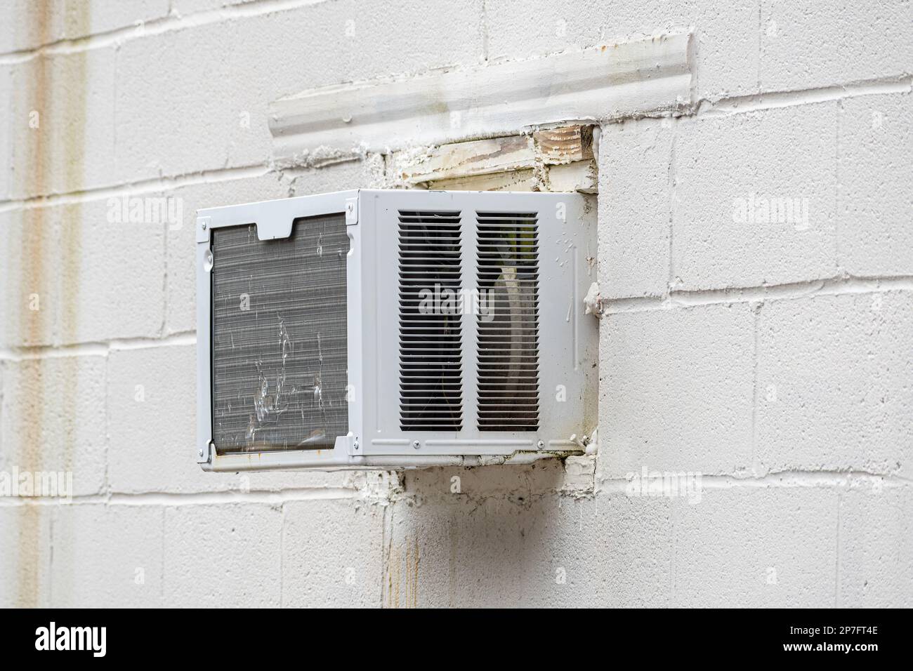 Horizontaler Schuss eines zerschmetterten Klimaanlagenfensters in einer Betonwand. Stockfoto