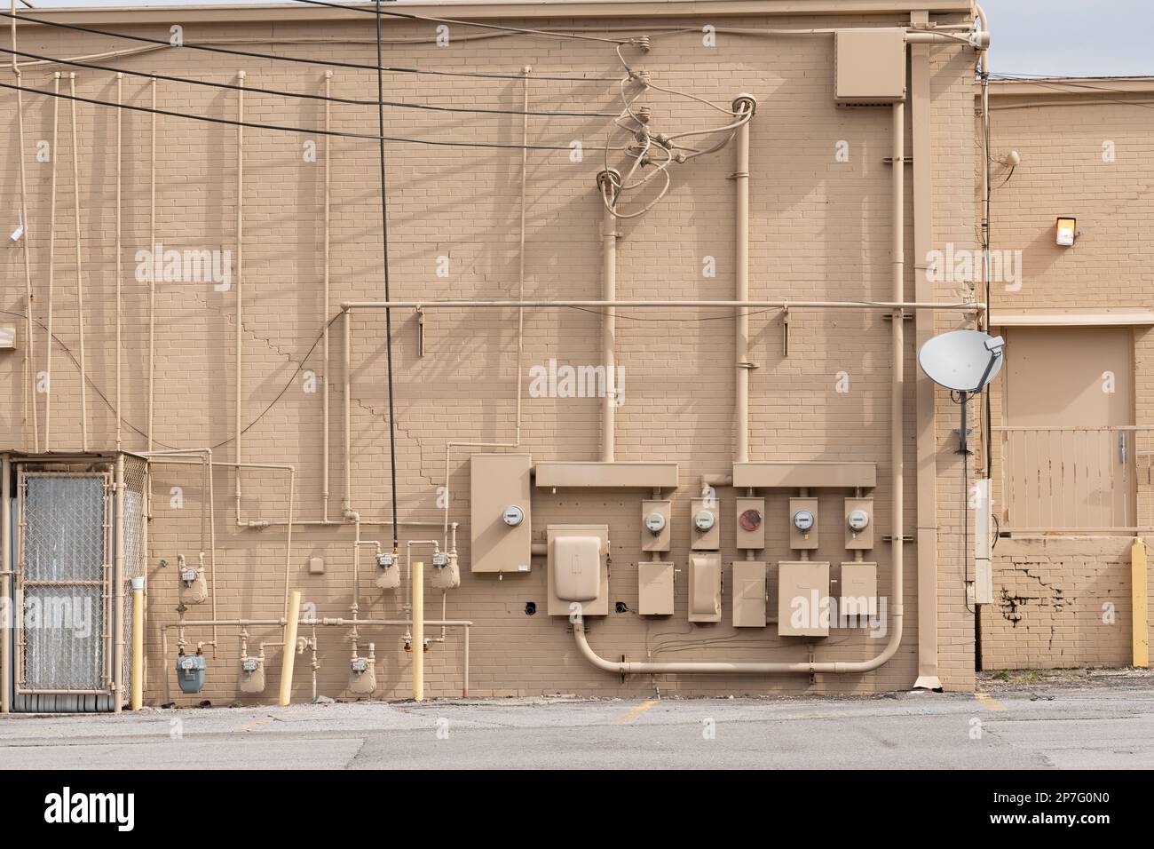 Horizontale Aufnahme eines verfallenen alten Einkaufszentrums mit elektrischen Zählern an einer Außenwand. Stockfoto