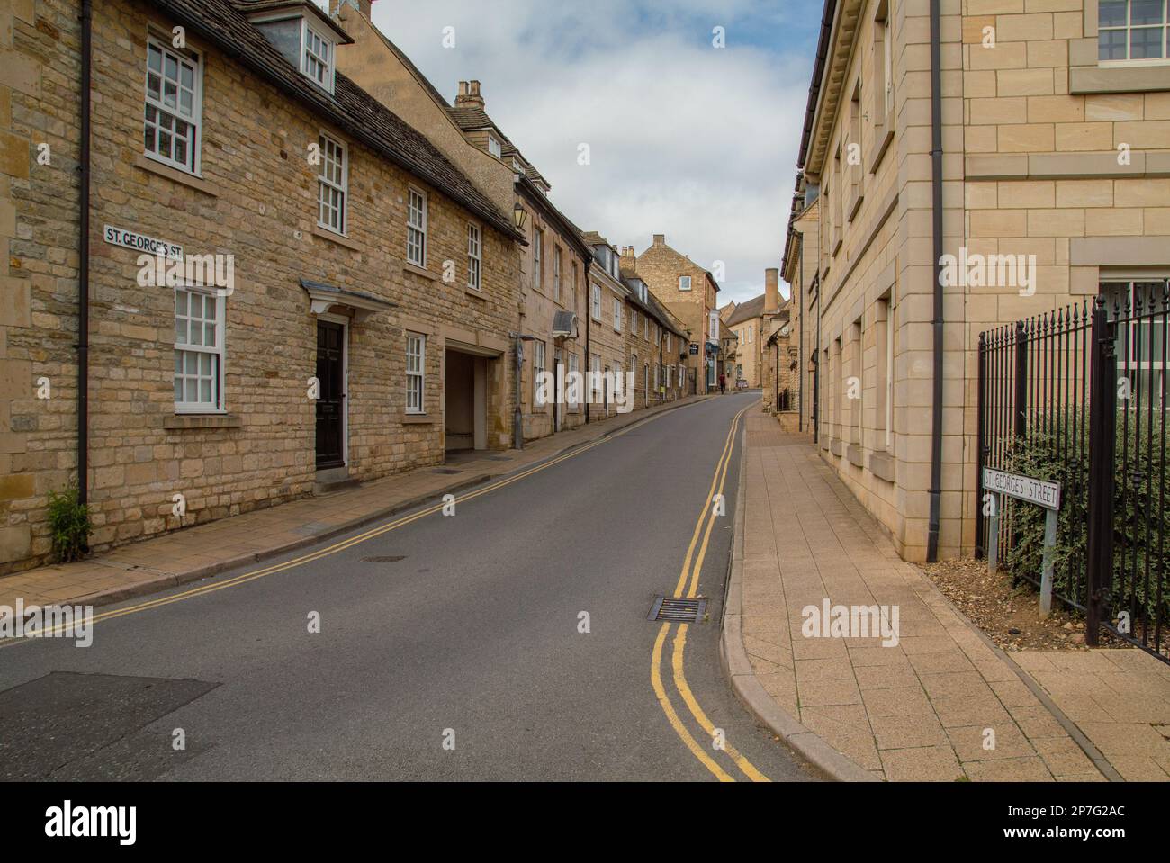 Ein Blick auf alte terrassenförmige Häuser in St. Georges Street, Stamford, Lincolnshire. Auf beiden Seiten der Straße verlaufen doppelte gelbe Linien. Stockfoto