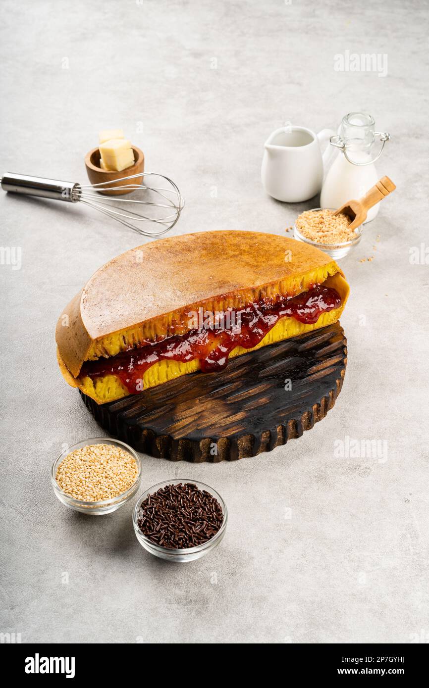 Martabak Manis oder Terang bulan ist ein süßer indonesischer Pfannkuchen mit gelber Farbe, gefüllt mit Schokoladenchips, Käse, Obstmarmelade, Butter und Erdnuss Stockfoto