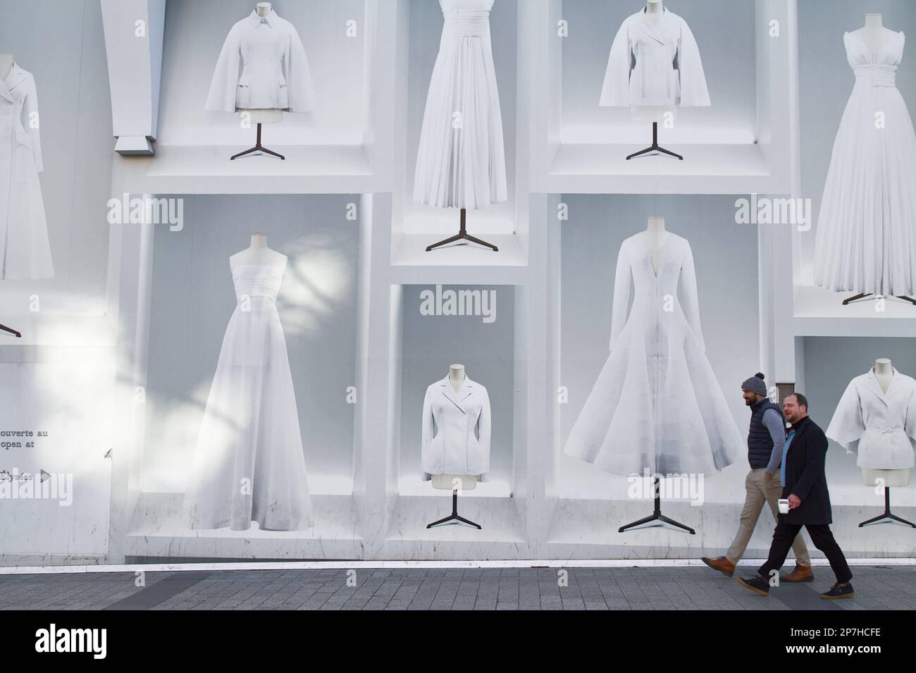 Zwei Personen gehen vorbei an der dekorierten Ladenfront des Christian Dior Shops auf den Champs Elysees, Paris, Frankreich Stockfoto