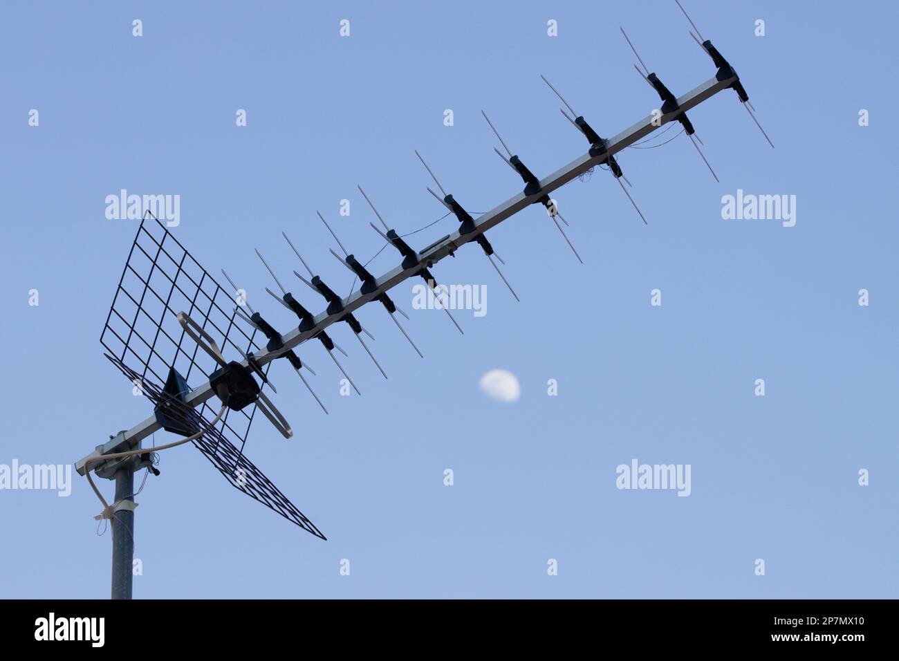 Nahaufnahme einer digitalen terrestrischen Fernsehantenne, in der sich ein Draht verheddert, mit blauem Himmel im Hintergrund Stockfoto