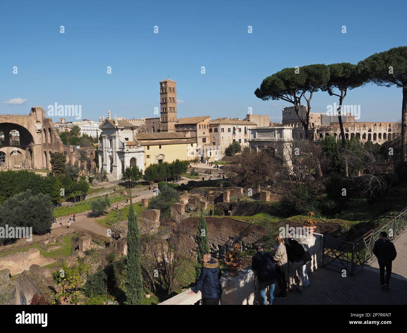Touristen genießen den Blick auf das Forum Romanum mit dem Kolosseum im Hintergrund im Stadtzentrum von Rom, Italien. Stockfoto