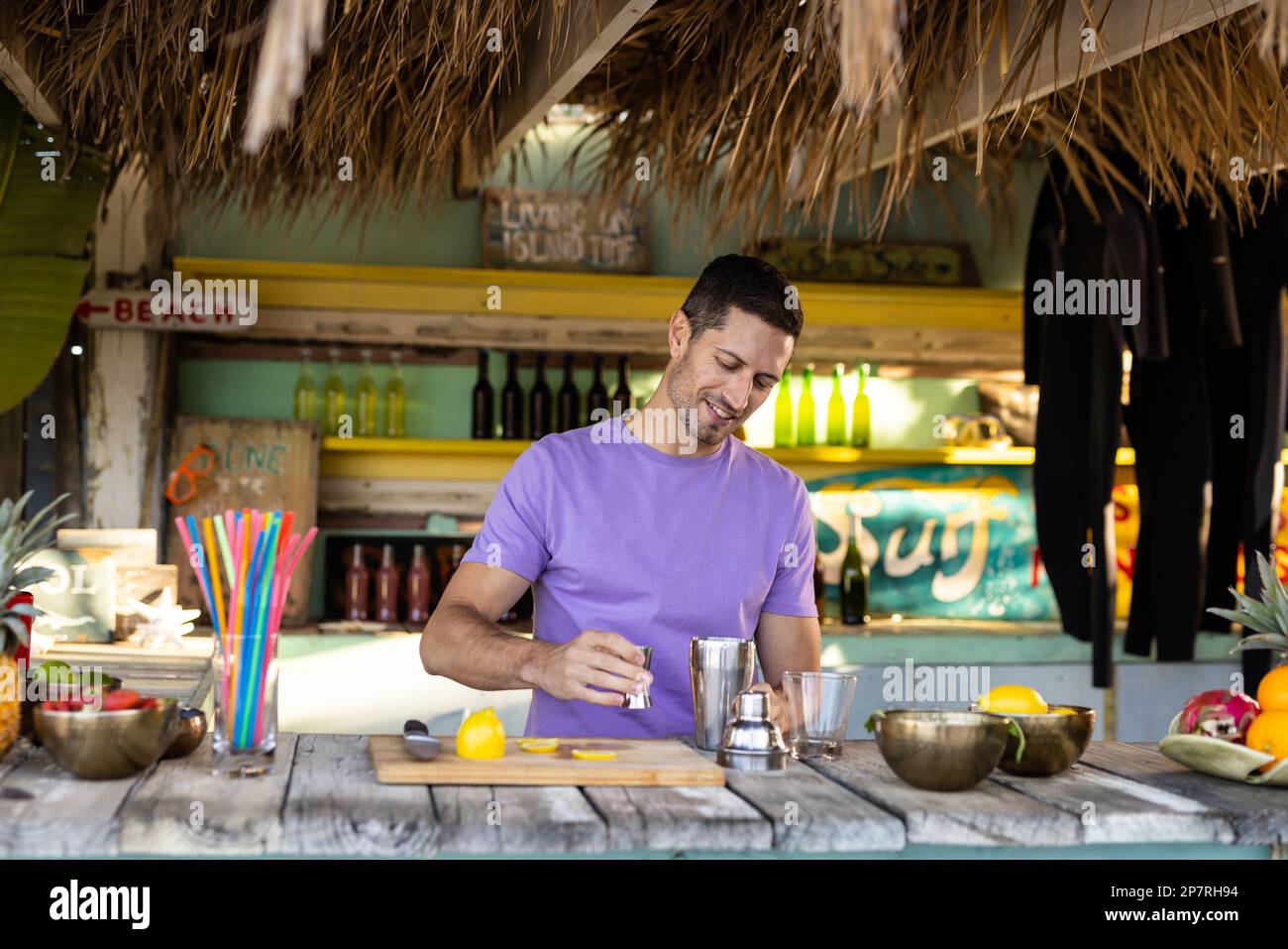 Fröhlicher birassischer Barkeeper, der Cocktails am Strand zubereitet. Verbringen Sie Zeit, Lebensstil, Sommerzeit und Urlaubskonzept. Stockfoto