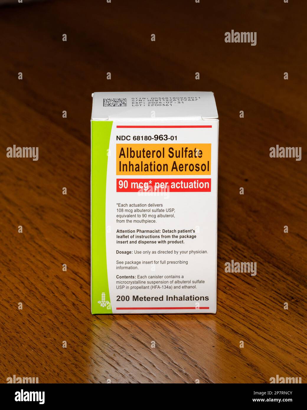 Eine Schachtel mit einem Albuterolsulfat-Inhalationsaerosol, einer Behandlung für Asthma und andere Atemprobleme isolierte einen Eichentisch Stockfoto