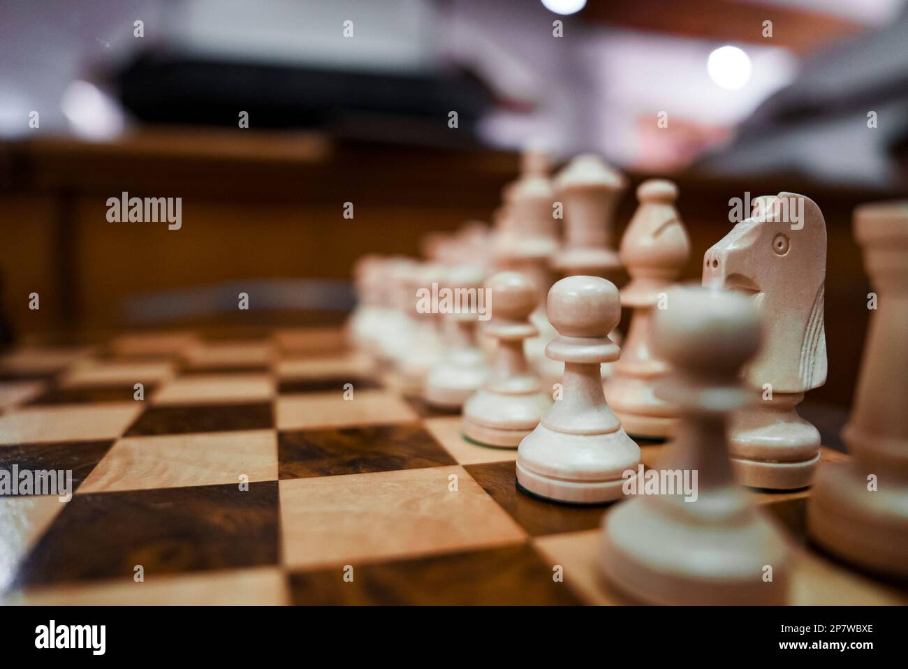 Weiße Schachfiguren aus Holz auf dem Schachbrett im Hotel Stockfoto