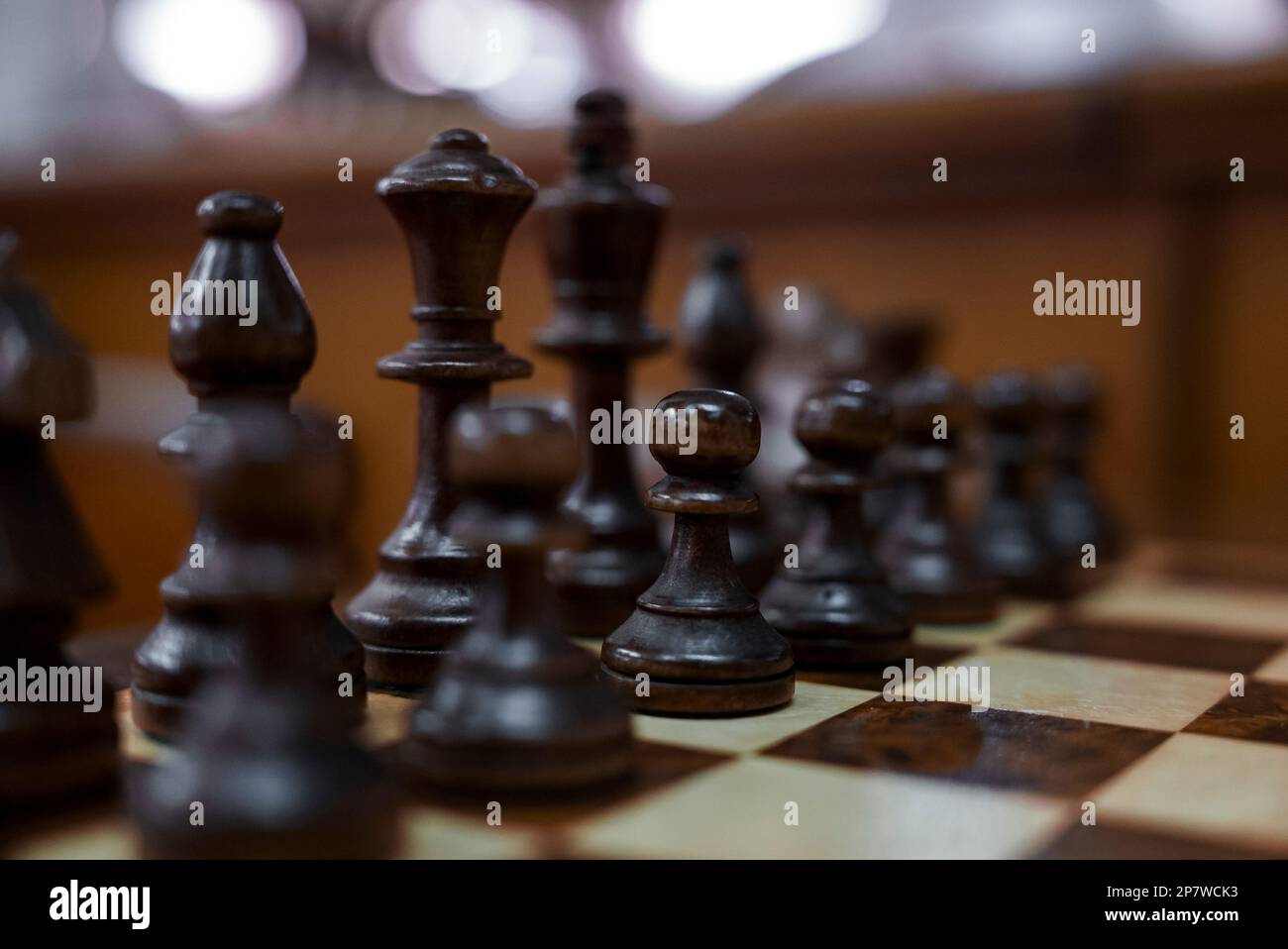 Nahaufnahme brauner Schachfiguren, die auf dem Schachbrett im Hotel angeordnet sind Stockfoto