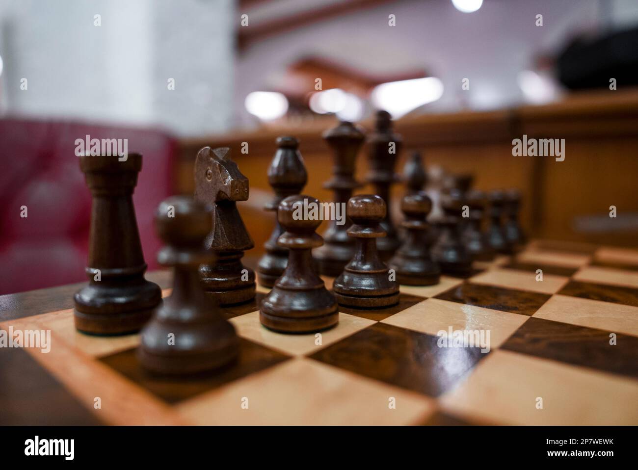 Nahaufnahme brauner Holzschachfiguren, die auf dem Schachbrett im Hotel angeordnet sind Stockfoto