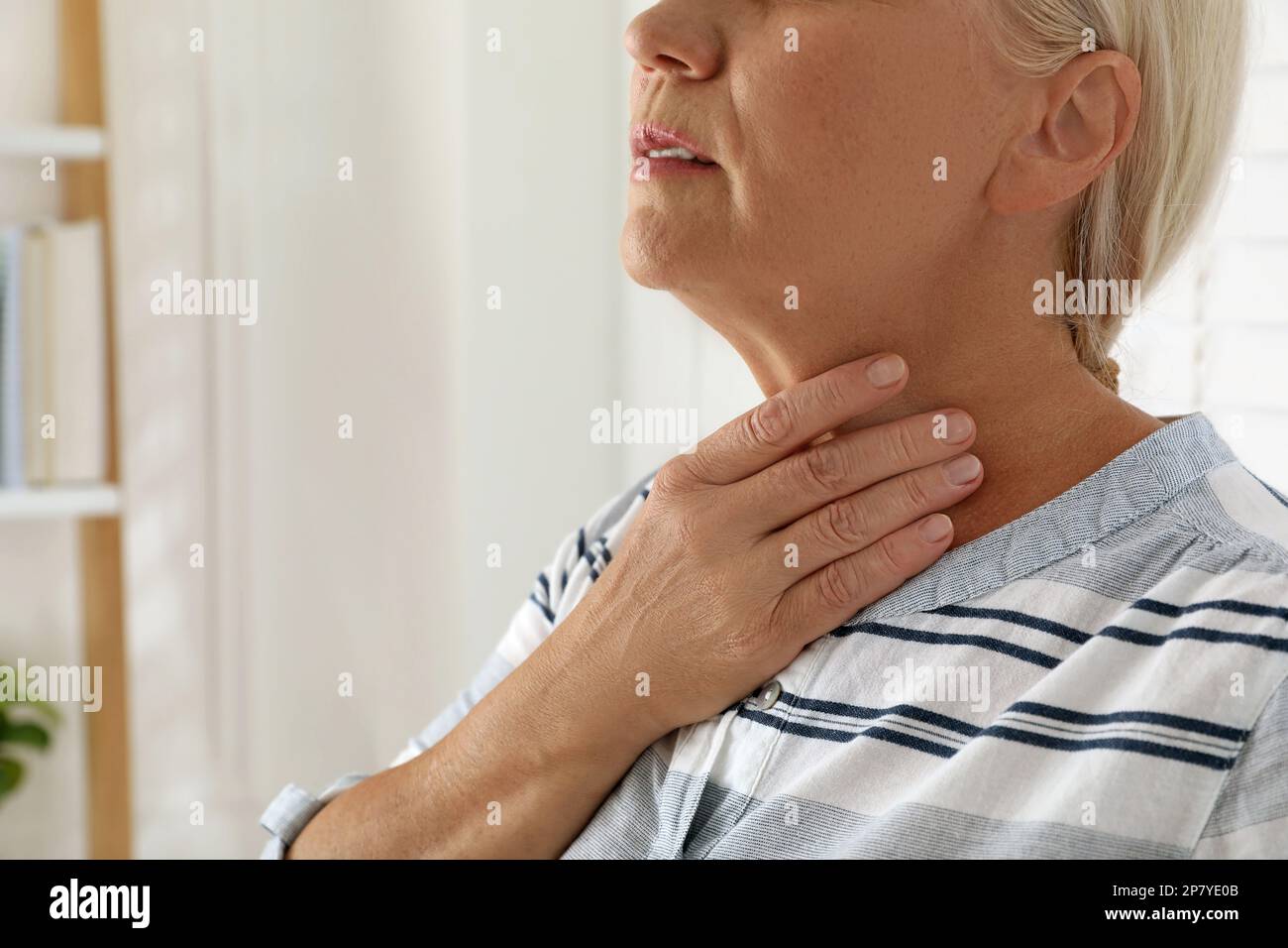 Reife Frau, die zu Hause eine Schilddrüsen-Selbstuntersuchung macht, Nahaufnahme. Platz für Text Stockfoto