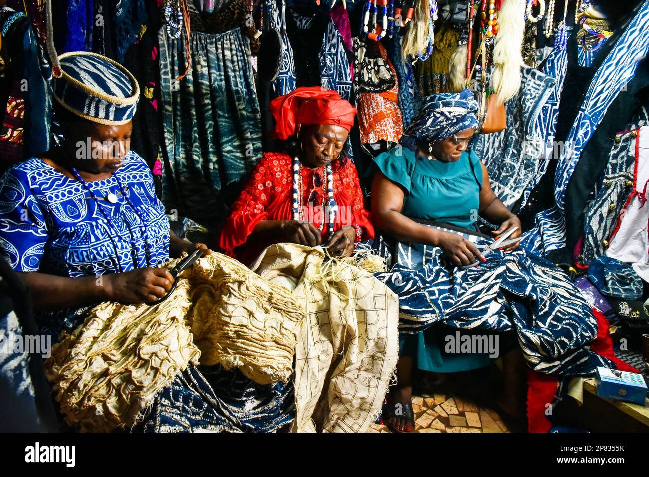 Yaounde, Kamerun. 3. März 2023. In einem Laden in Bafoussam, Kamerun, am 3. März 2023 weben Frauen Ndop-Designs mit Raffiafasern. In Kamerun waren Kunsthandwerk wie Nähen, Steppnähen, Stickereien und Stricken schon immer ein Ventil für Frauen, um ihre Kreativität zu nutzen. Ndop-Material wurde ursprünglich von Frauen hergestellt und war ein wichtiges Symbol für sozialen Status und kulturelles Erbe, aber heute - auf eine andere Weise - verbessert es das Leben von Frauen.ZU "Feature: Ndop Fabric verwandelt Frauen in Kleinstunternehmer in Kamerun" zu KOMMEN Kredit: Kepseu/Xinhua/Alamy Live News Stockfoto