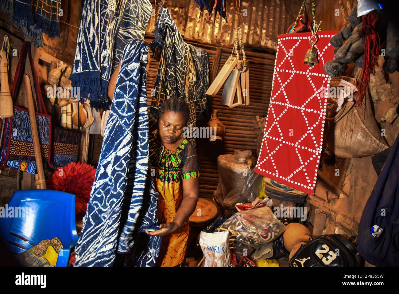 Yaounde, Kamerun. 3. März 2023. Ein Händler arrangiert Ndop-Produkte auf einem Markt in Bafoussam, Kamerun, 3. März 2023. In Kamerun waren Kunsthandwerk wie Nähen, Steppnähen, Stickereien und Stricken schon immer ein Ventil für Frauen, um ihre Kreativität zu nutzen. Ndop-Material wurde ursprünglich von Frauen hergestellt und war ein wichtiges Symbol für sozialen Status und kulturelles Erbe, aber heute - auf eine andere Weise - verbessert es das Leben von Frauen.ZU "Feature: Ndop Fabric verwandelt Frauen in Kleinstunternehmer in Kamerun" zu KOMMEN Kredit: Kepseu/Xinhua/Alamy Live News Stockfoto