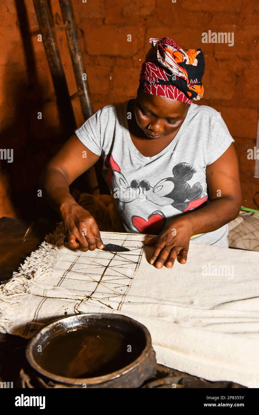 (230309) -- YAOUNDE, 9. März 2023 (Xinhua) -- Flore Amedite Kammogne zeichnet Muster auf einem Stoff, um den traditionellen Ndop in ihrer Werkstatt in Baham, Kamerun, am 3. März 2023 herzustellen. In Kamerun waren Kunsthandwerk wie Nähen, Steppnähen, Stickereien und Stricken schon immer ein Ventil für Frauen, um ihre Kreativität zu nutzen. Ndop-Material wurde ursprünglich von Frauen hergestellt und war ein wichtiges Symbol für sozialen Status und kulturelles Erbe, aber heute - auf eine andere Weise - verbessert es das Leben von Frauen.ZU "Feature: Ndop-Material verwandelt Frauen in Kleinstunternehmer in Kamerun" (Xinhua/Kepseu) Stockfoto