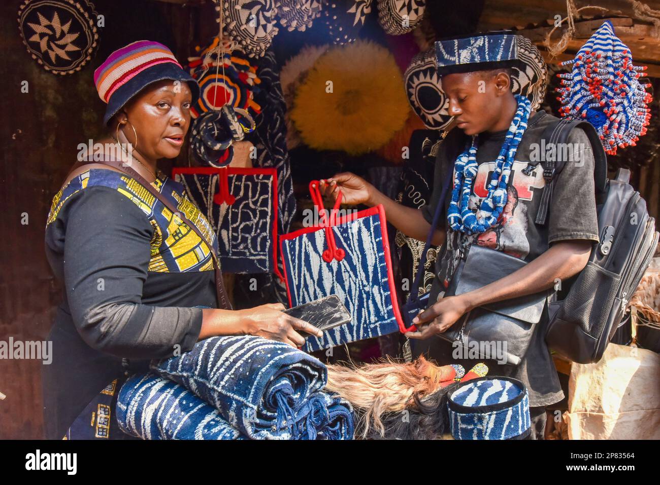 Yaounde, Kamerun. 3. März 2023. Eine Frau verkauft Ndop-Produkte auf einem Marktplatz in Bafoussam, Kamerun, 3. März 2023. In Kamerun waren Kunsthandwerk wie Nähen, Steppnähen, Stickereien und Stricken schon immer ein Ventil für Frauen, um ihre Kreativität zu nutzen. Ndop-Material wurde ursprünglich von Frauen hergestellt und war ein wichtiges Symbol für sozialen Status und kulturelles Erbe, aber heute - auf eine andere Weise - verbessert es das Leben von Frauen.ZU "Feature: Ndop Fabric verwandelt Frauen in Kleinstunternehmer in Kamerun" zu KOMMEN Kredit: Kepseu/Xinhua/Alamy Live News Stockfoto