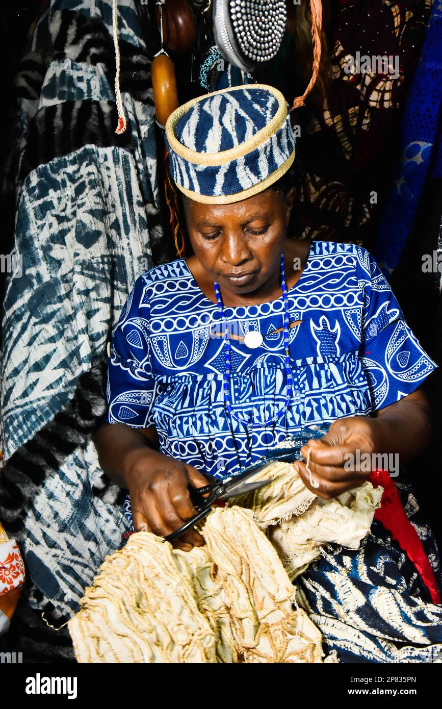 Yaounde, Kamerun. 3. März 2023. Ein Lehrling webt die Entwürfe von Ndop mit Raffiafasern in einem Laden in Bafoussam, Kamerun, am 3. März 2023. In Kamerun waren Kunsthandwerk wie Nähen, Steppnähen, Stickereien und Stricken schon immer ein Ventil für Frauen, um ihre Kreativität zu nutzen. Ndop-Material wurde ursprünglich von Frauen hergestellt und war ein wichtiges Symbol für sozialen Status und kulturelles Erbe, aber heute - auf eine andere Weise - verbessert es das Leben von Frauen.ZU "Feature: Ndop Fabric verwandelt Frauen in Kleinstunternehmer in Kamerun" zu KOMMEN Kredit: Kepseu/Xinhua/Alamy Live News Stockfoto