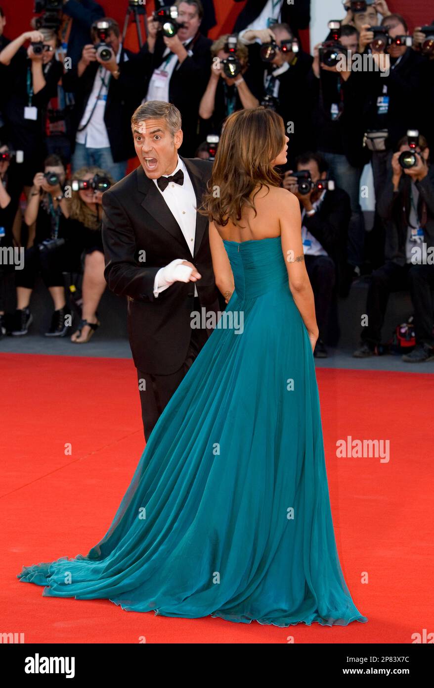 US actor George Clooney reacts on the red carpet as he arrives with Italian actress Elisabetta Canalis for the screening of the film ' The Men Who Stare at Goats ' at the 66th edition of the Venice Film Festival in Venice, Italy, Tuesday, Sept. 8, 2009. (AP Photo/Domenico Stinellis) Stockfoto