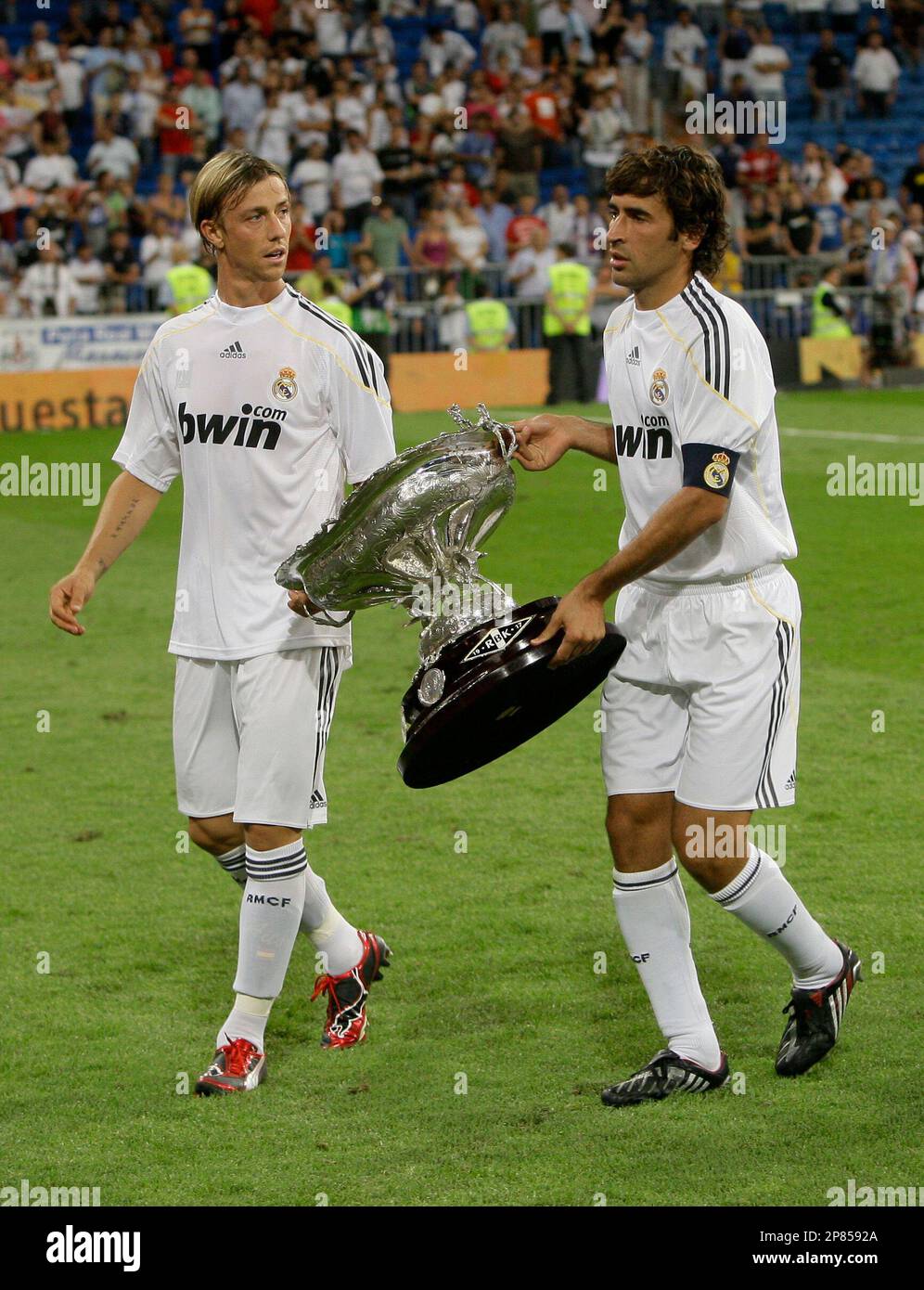 Real Madrid's Raul Gonzalez, left and Jose Maria Gurtierrez 'Guti' carry the Santiago Bernabeu trophy after beating Rosenborg 4-0 in the Santiago Bernabeu stadium in Madrid, Tuesday Aug. 25, 2009. (AP Photo/Paul White) Stockfoto