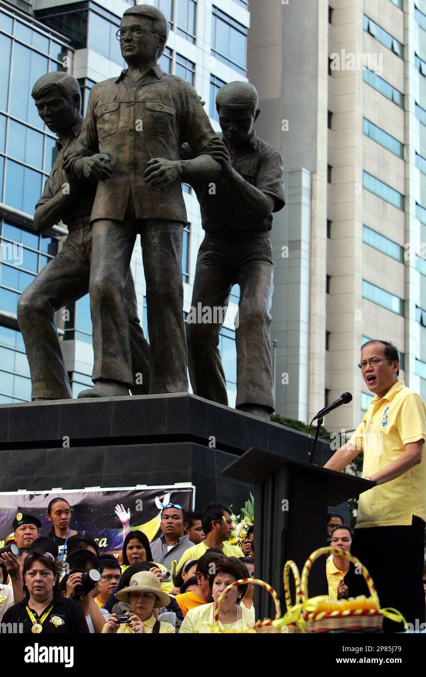 Senator Benigno "Noynoy" Aquino III delivers his message beside the statue of his father and the late Senator Benigno Aquino Jr. during the commemoration of the latter's 26th death anniversary and a mass for his wife the late President Corarzon "Cory" Aquino Friday, Aug. 21, 2009 at Manila's financial district of Makati, Philippines. The assassination of Senator Aquino Jr. in 1983 led to a "People Power" that ousted the late strongman President Ferdinand Marcos and catapulted his wife Corazon Aquino into power. (AP Photo/ Pat Roque) Stockfoto