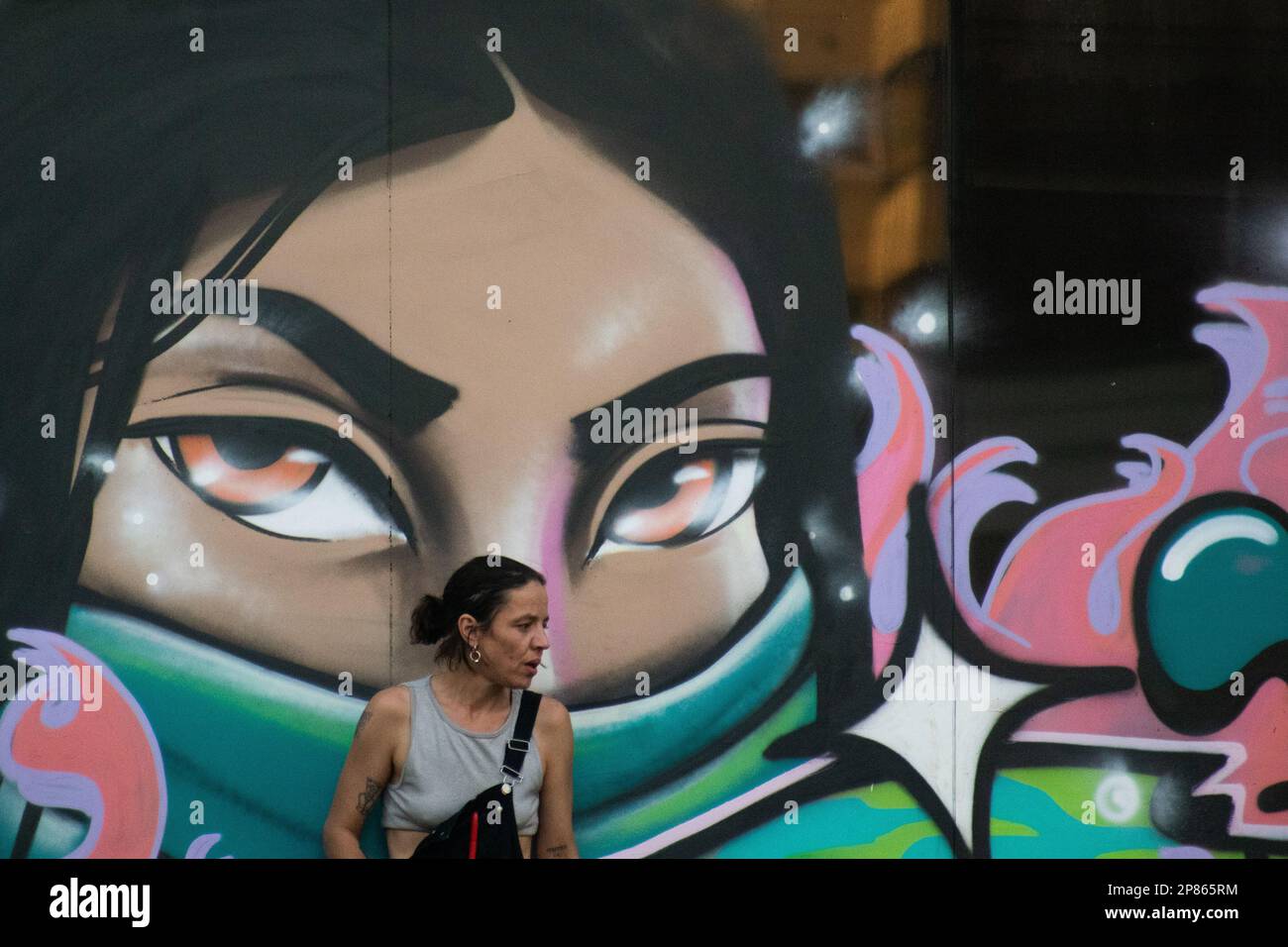 Santiago, Metropolitana, Chile. 8. März 2023. Eine Frau lehnt sich auf ein Wandgemälde, das während des Internationalen Frauentags in Santiago, Chile, gemalt wurde. (Kreditbild: © Matias Basualdo/ZUMA Press Wire) NUR REDAKTIONELLE VERWENDUNG! Nicht für den kommerziellen GEBRAUCH! Kredit: ZUMA Press, Inc./Alamy Live News Stockfoto