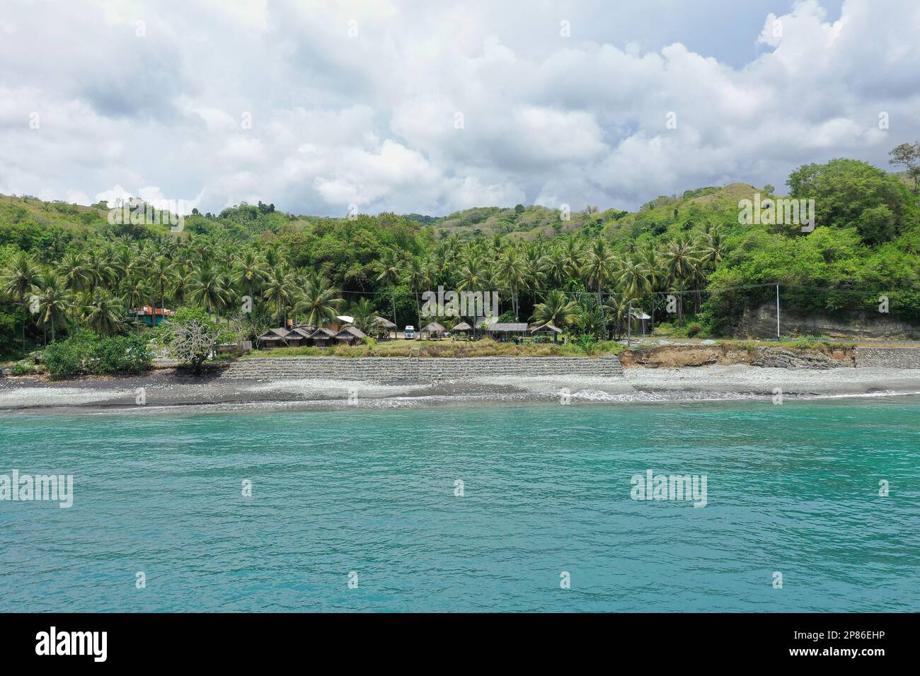 Panorama Drohne am Strand Pantai Batu Biru, Blue Stone Beach, im Vordergrund des türkisfarbenen Meeres. Stockfoto