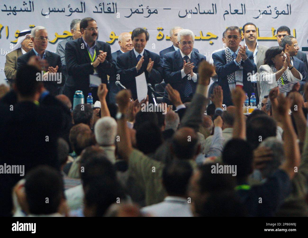 Fatah members applaud Palestinian President Mahmoud Abbas, centre right, during the Fatah party convention in the West Bank town of Bethlehem, Saturday, Aug. 8, 2009. Palestinian President Mahmoud Abbas was re-elected Saturday to lead Fatah by consensus at his party's first conference in two decades, strengthening the hand of the Western-backed leader to revive peace talks with Israel. (AP Photo/Nasser Shiyoukhi) Stockfoto