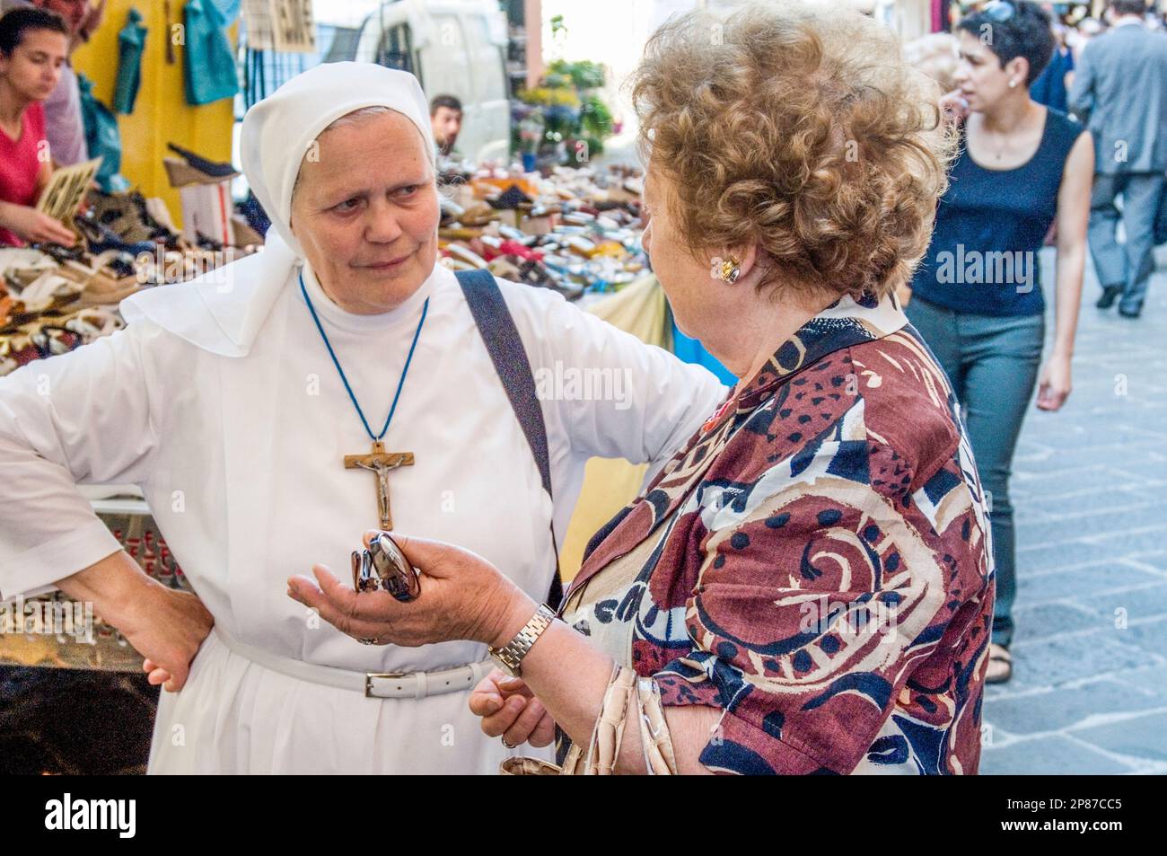 Eine Nonne und eine andere Frau, die sich auf einem Straßenmarkt unterhalten, Camogli, Riviera di Levante, Italien Stockfoto