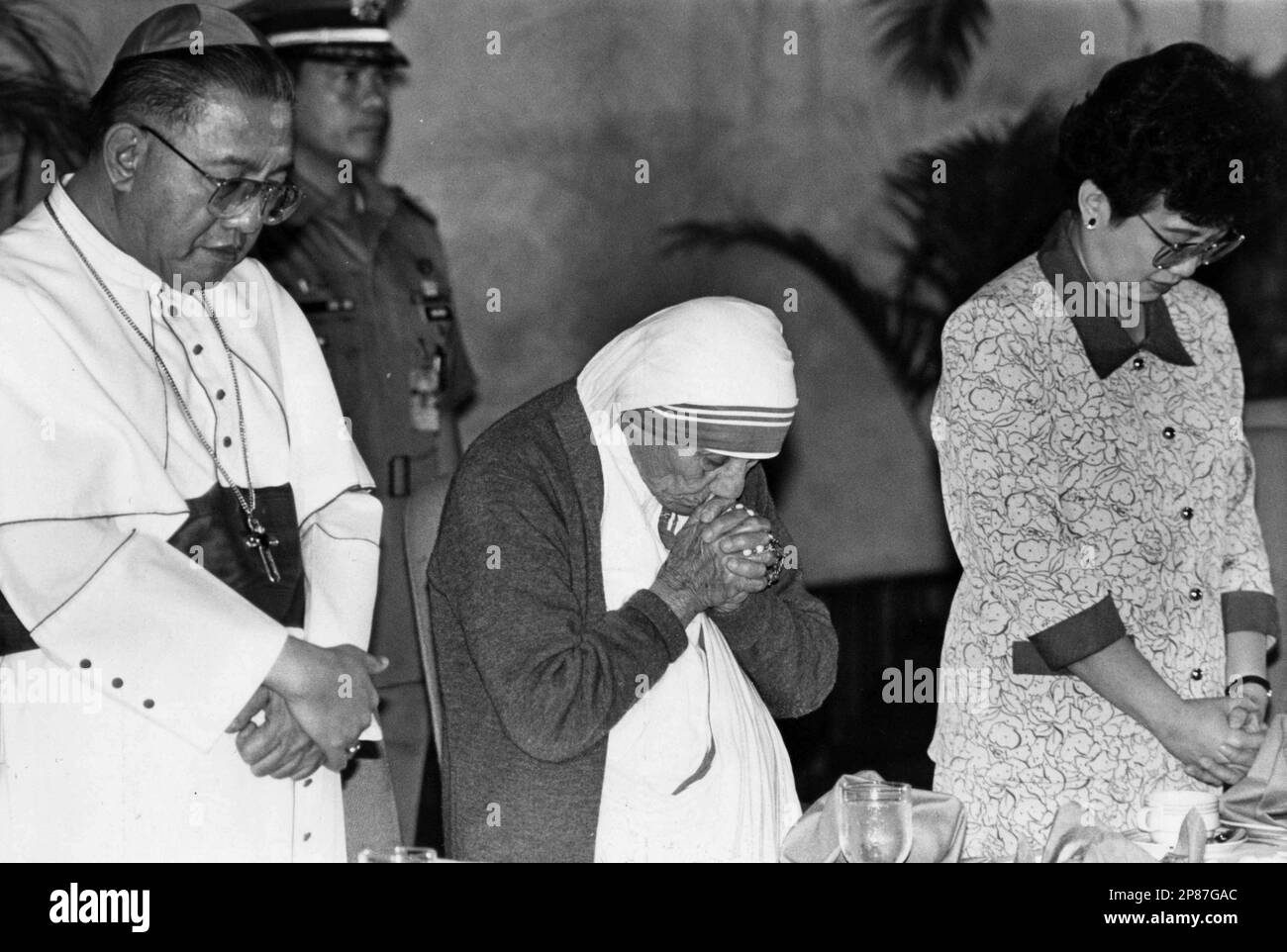 FILE-- In this March 16, 1986 file photo Mother Theresa, center, former Philippine President Corazon "Cory" Aquino, right, and the late Manila Archbishop Cardinal Jaime Sin, pray during Mother Theresa's visit to the Philippines. Aquino, who swept away a dictator with a "people power" revolt and then sustained democracy by fighting off seven coup attempts in six years, died on Saturday, Aug. 1, 2009, her son said. She was 76. (AP Photo/Bullit Marquez, File) Stockfoto