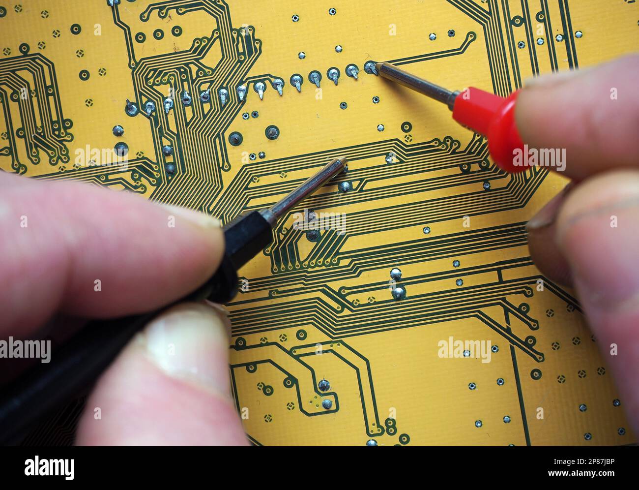 Fehlererkennung mit Prüfspitzen auf einer digitalen Platine. Reparatur eines elektronischen Geräts. Hintergrund der Elektronikindustrie. Stockfoto