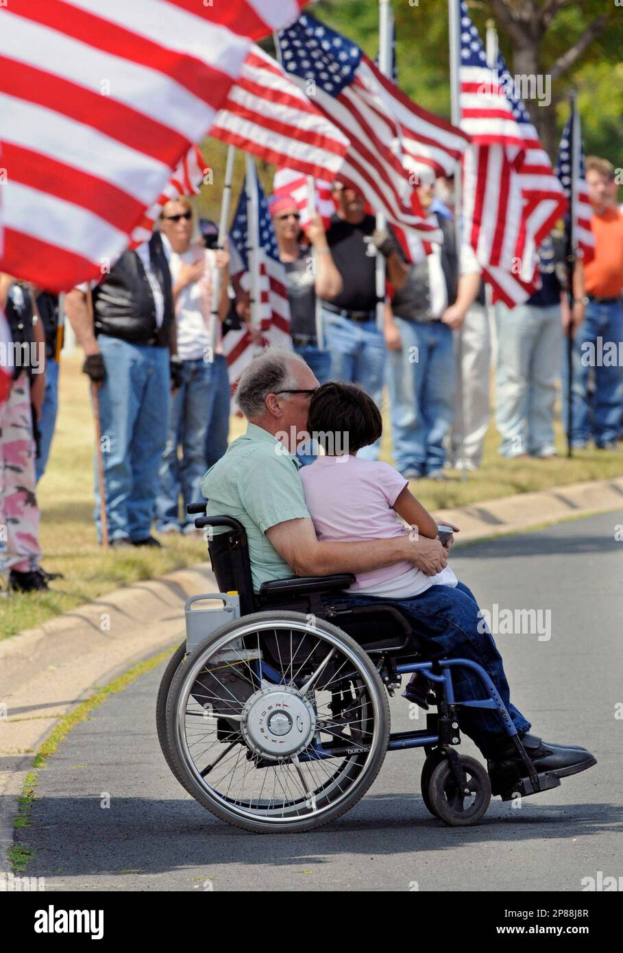 Patriot guard riders line the road behind george bonfe of forest lake