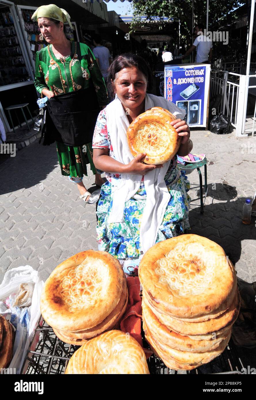 Eine usbekische Frau, die Obi Non verkauft - ein traditionelles usbekisches / tadschikisches Brot, das auf dem Markt in Bukhara, Usbekistan, verkauft wird. Stockfoto