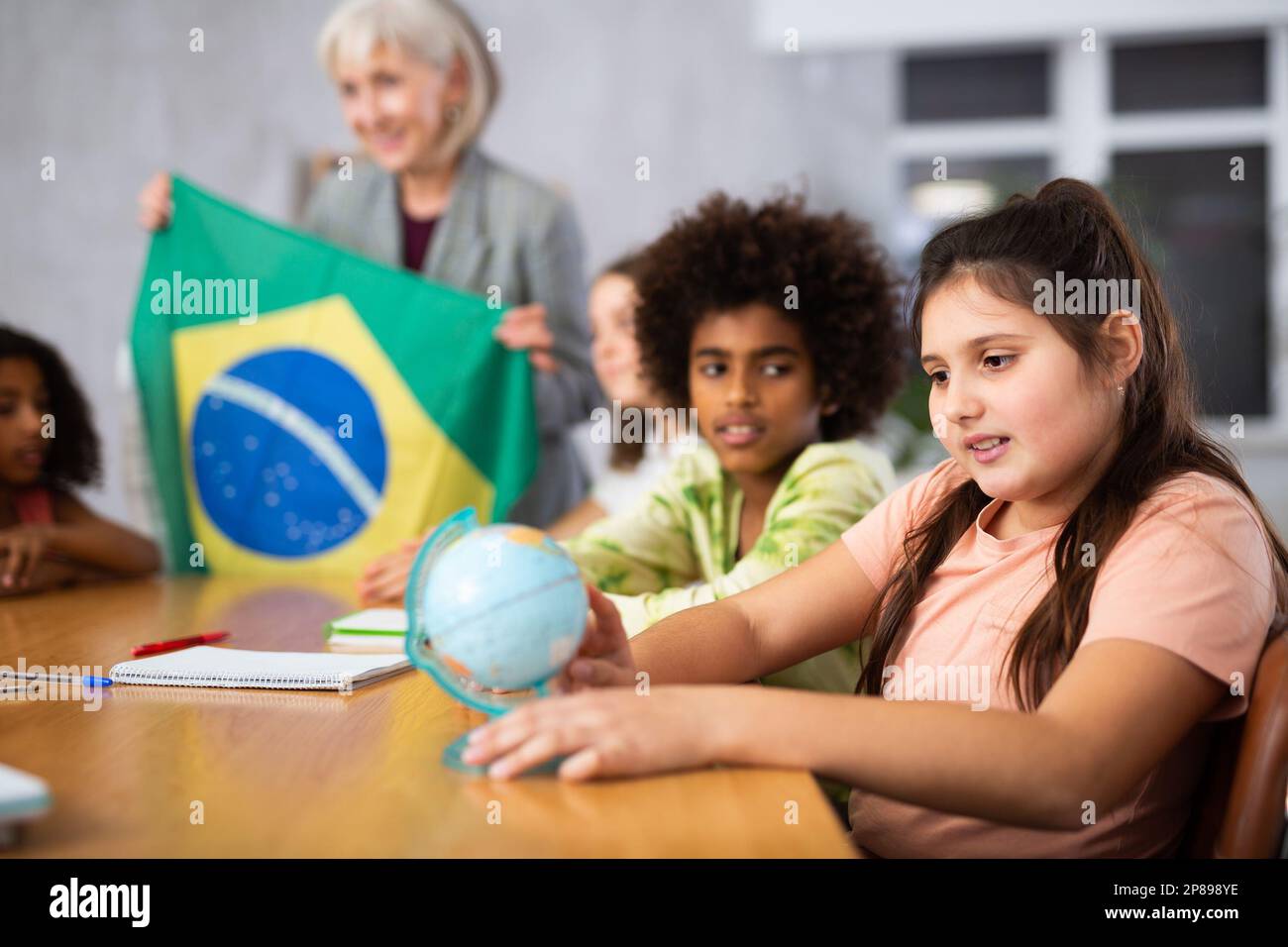 Eine reife Lehrerin erzählt den Schülern die Geschichte Brasiliens Stockfoto
