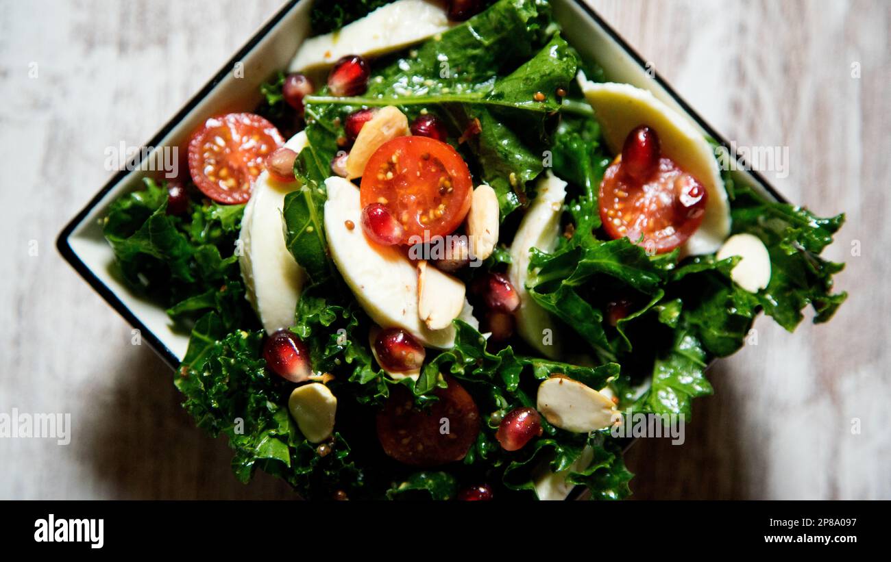 Köstlicher und gesunder Grünkohlsalat, Mozzarella-Käse und Kirschtomaten. Stockfoto