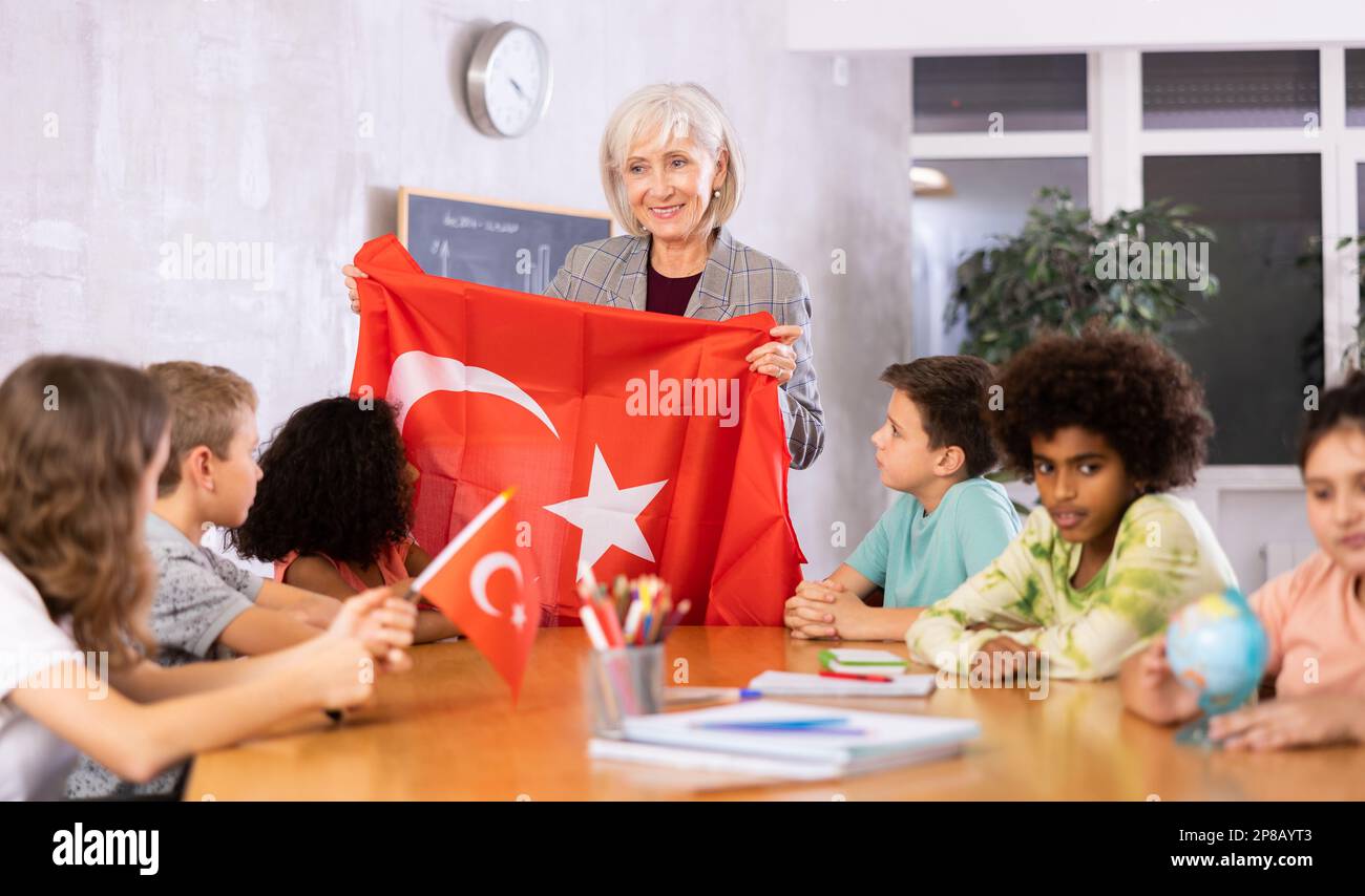 Eine lächelnde, reife Lehrerin erzählt den Schülern die Geschichte der Türkei Stockfoto