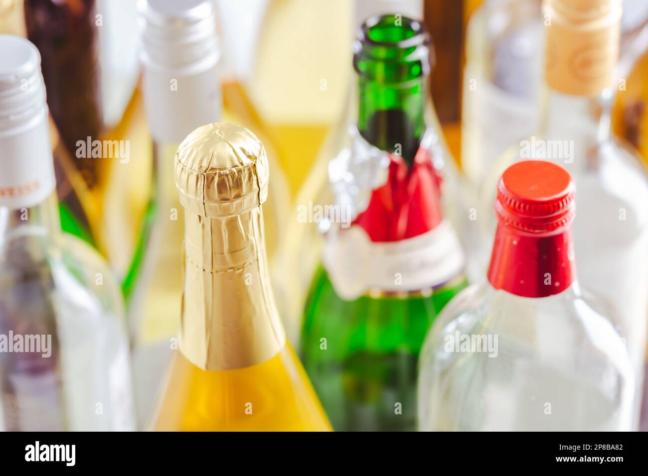 Volle und leere Flaschen verschiedener alkoholischer Getränke, Missbrauch und Alkoholabhängigkeit. Alkoholismusbegriff. Stockfoto