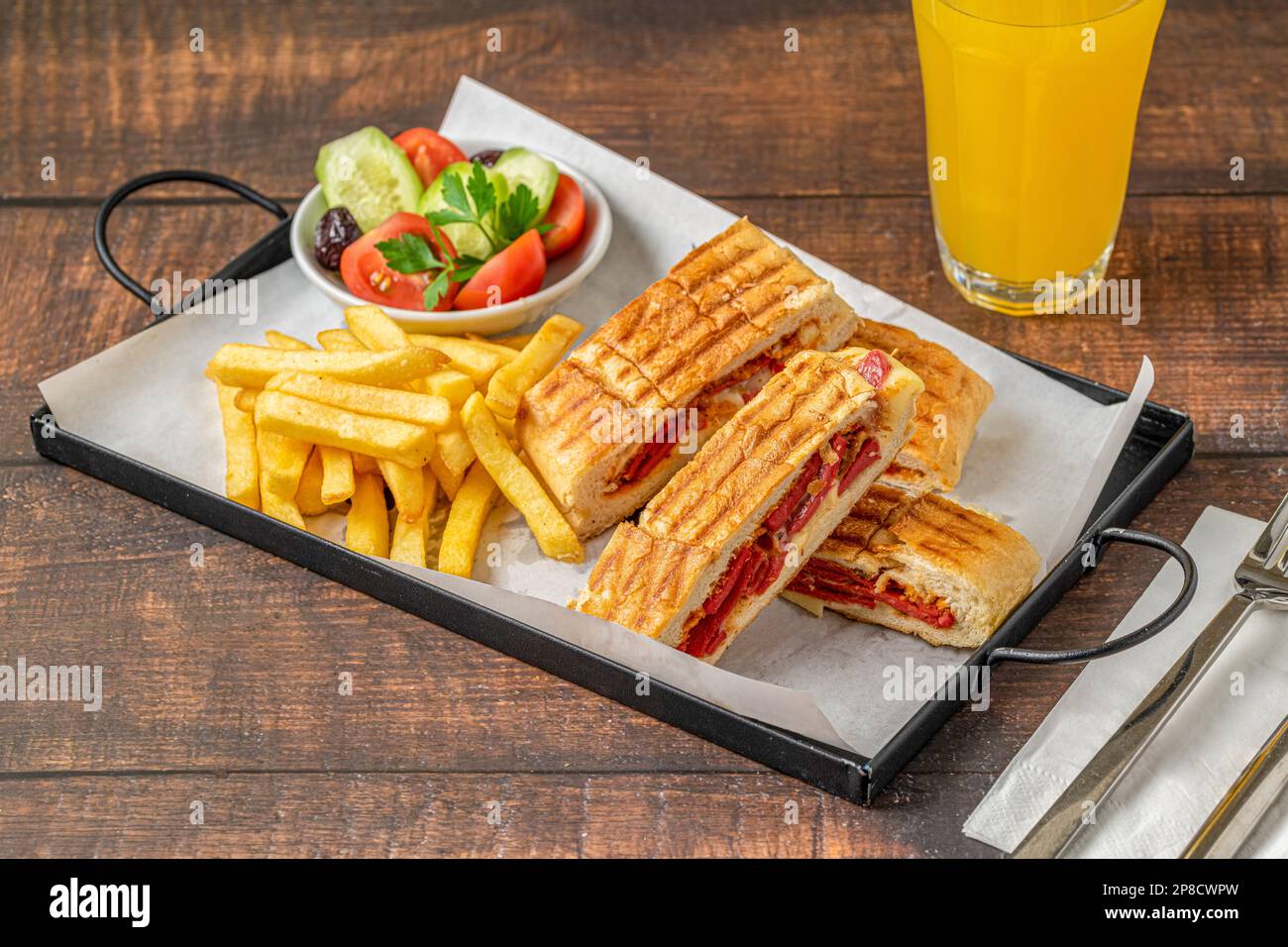 Toast mit Cheddar Käse und türkischer Wurst mit pommes Frites und Salat auf einem Holztisch Stockfoto