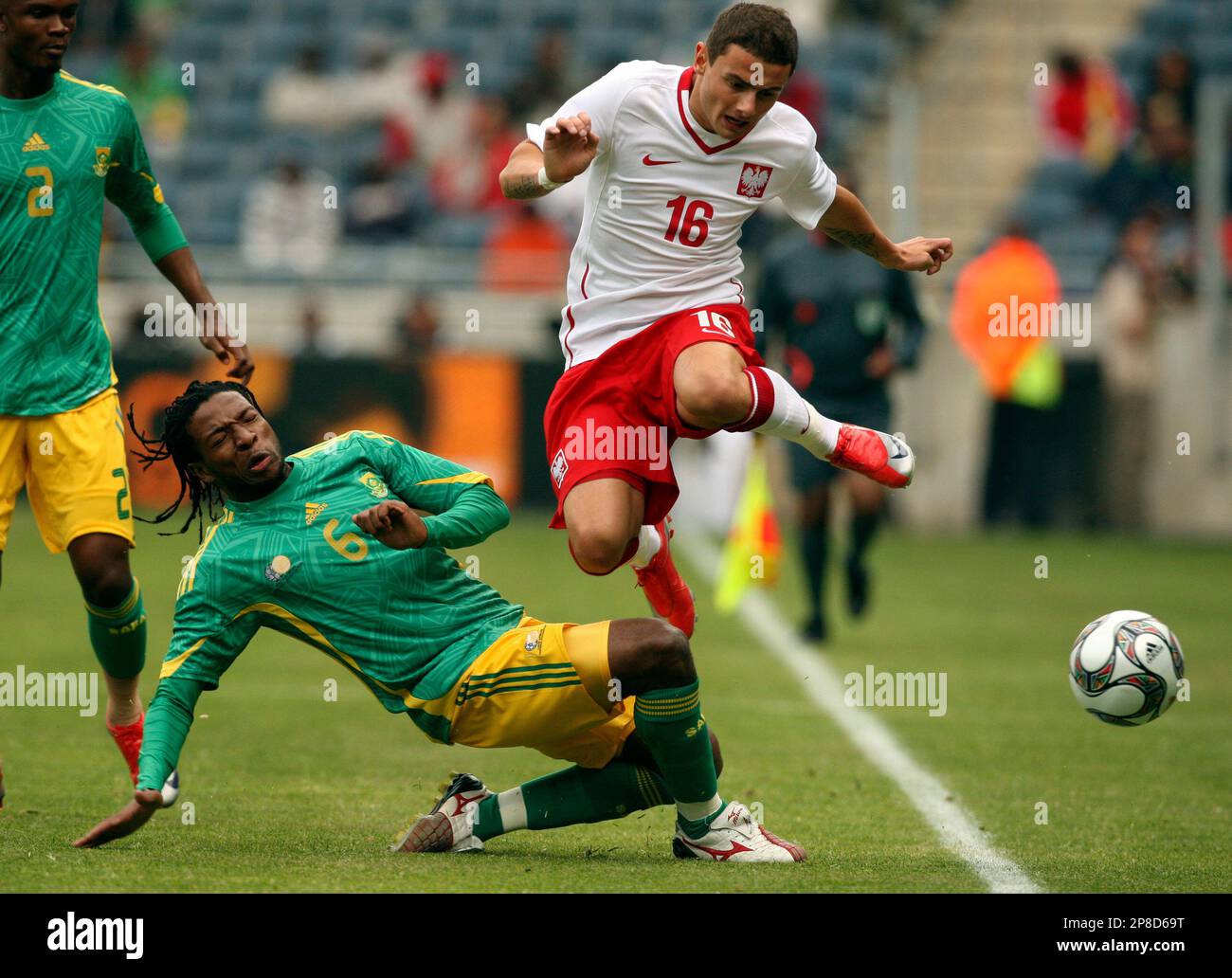 Poland's Jakub Wilk, right, jumps as South Africa's Macbeth Sibaya, left, tackles him during the international friendly soccer match at the Orlando stadium in Soweto, South Africa, Saturday, June 6, 2009. (AP Photo/Themba Hadebe) Stockfoto