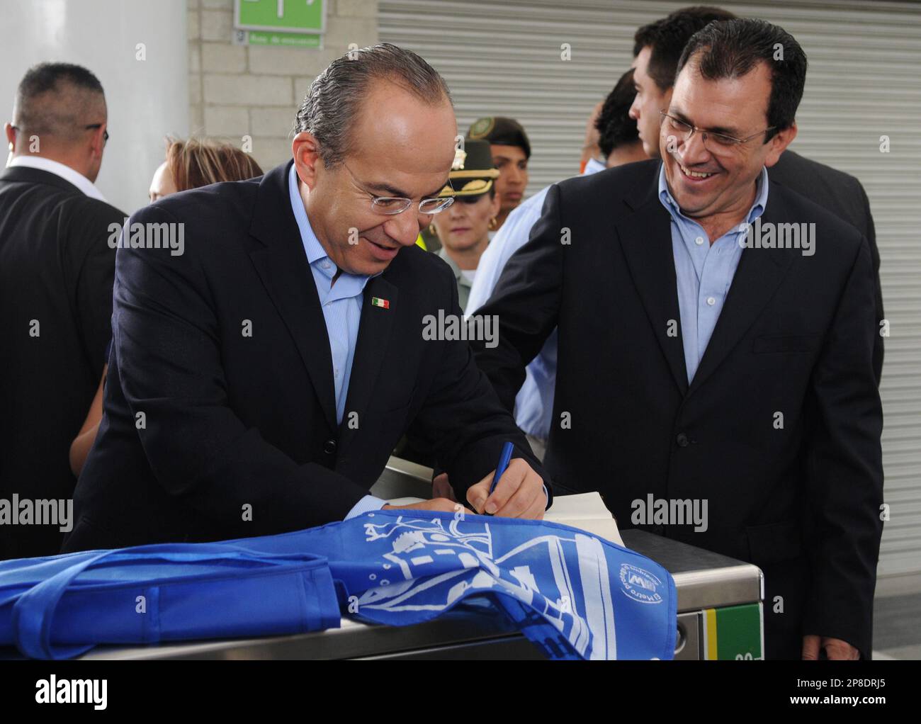 Mexico's President Felipe Calderon, left, signs a visitors book during