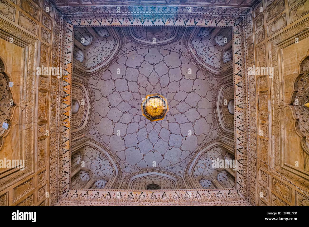Die Decke des Gebetssaals ist mit eleganten Blumenfresken und Muqarnas im nahöstlichen Stil verziert, die in @Lahore, Pakistan, aufgenommen wurden Stockfoto