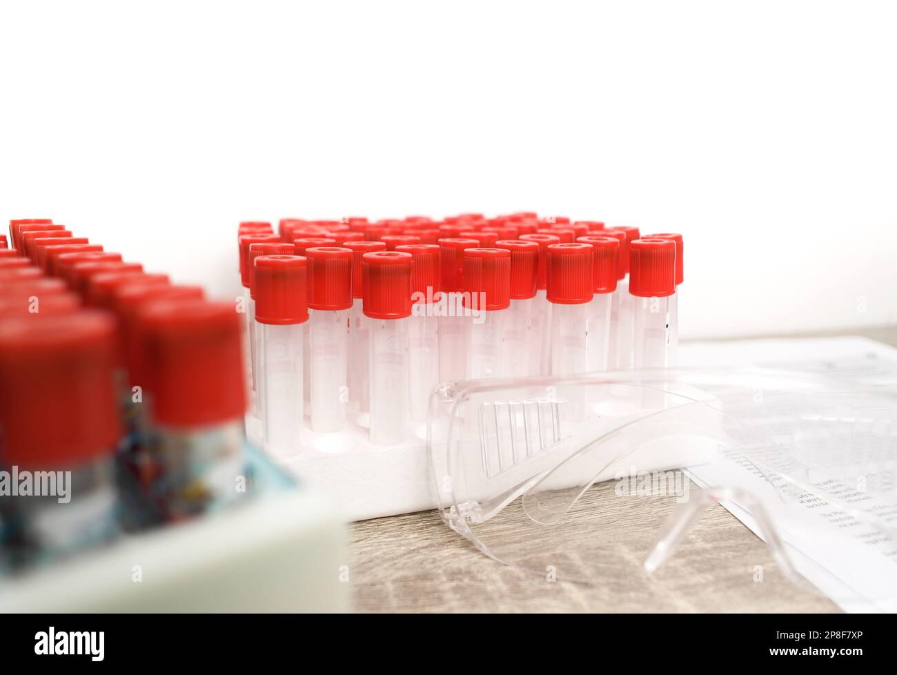 Ein leeres Blutprobenröhrchen mit roter Kappe auf dem Schreibtisch im Hämatologielabor, Hämatologie-Labor-Konzept Stockfoto