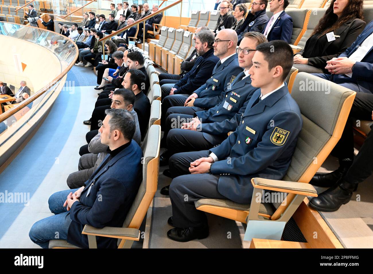 Düsseldorf, Deutschland. 09. März 2023. Mitarbeiter des Deutschen Bundesamtes für Technische Hilfe (THW) und anderer Hilfsorganisationen beobachten die Debatte über die Erdbebenkatastrophe in Syrien und der Türkei im landesparlament. Die Abgeordneten dankten den Helfern aus Deutschland und Nordrhein-Westfalen, die in den ersten Stunden geholfen haben, die begrabenen Menschen aus den Trümmern zu befreien. Kredit: Roberto Pfeil/dpa/Alamy Live News Stockfoto