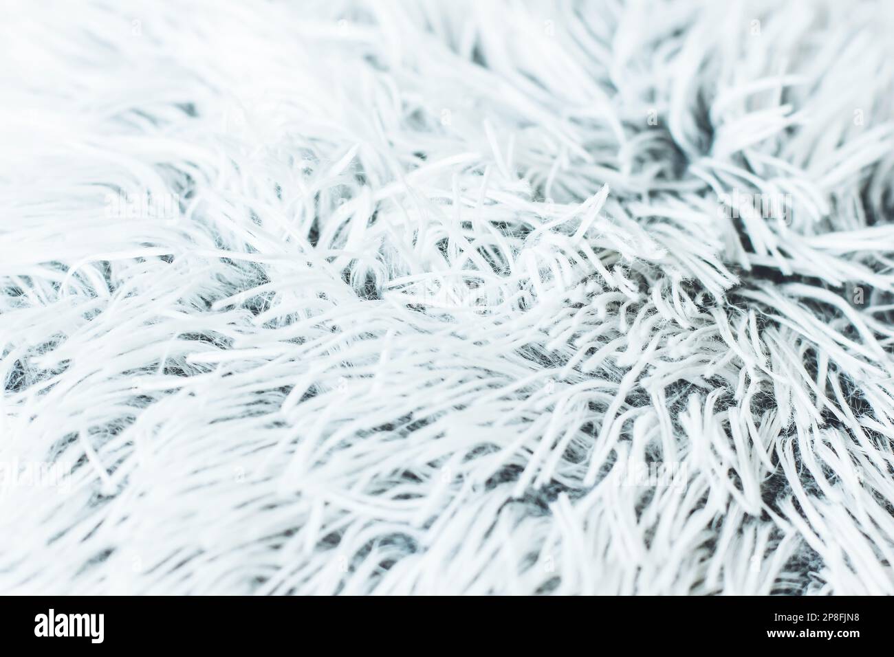 Kunstkissen-Nahaufnahme. Details der Plüschfläche. Attraktive Textur, glatte Kurven. Kissen in neutralen Farben. Nahaufnahme des Stoffhintergrunds. Stockfoto