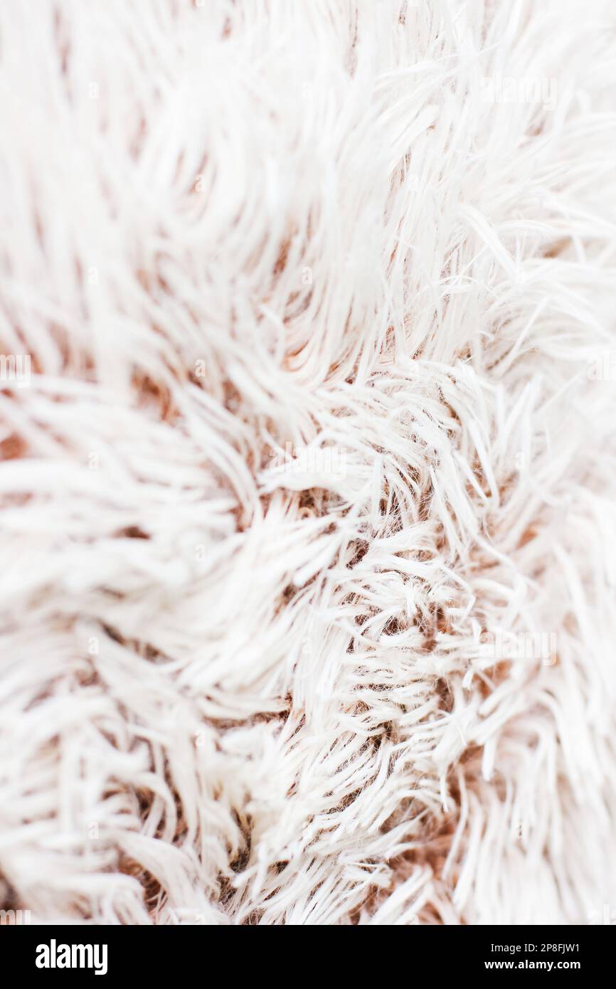 Kunstkissen-Nahaufnahme. Details der Plüschfläche. Attraktive Textur, glatte Kurven. Kissen in neutralen Farben. Nahaufnahme des Stoffhintergrunds. Stockfoto