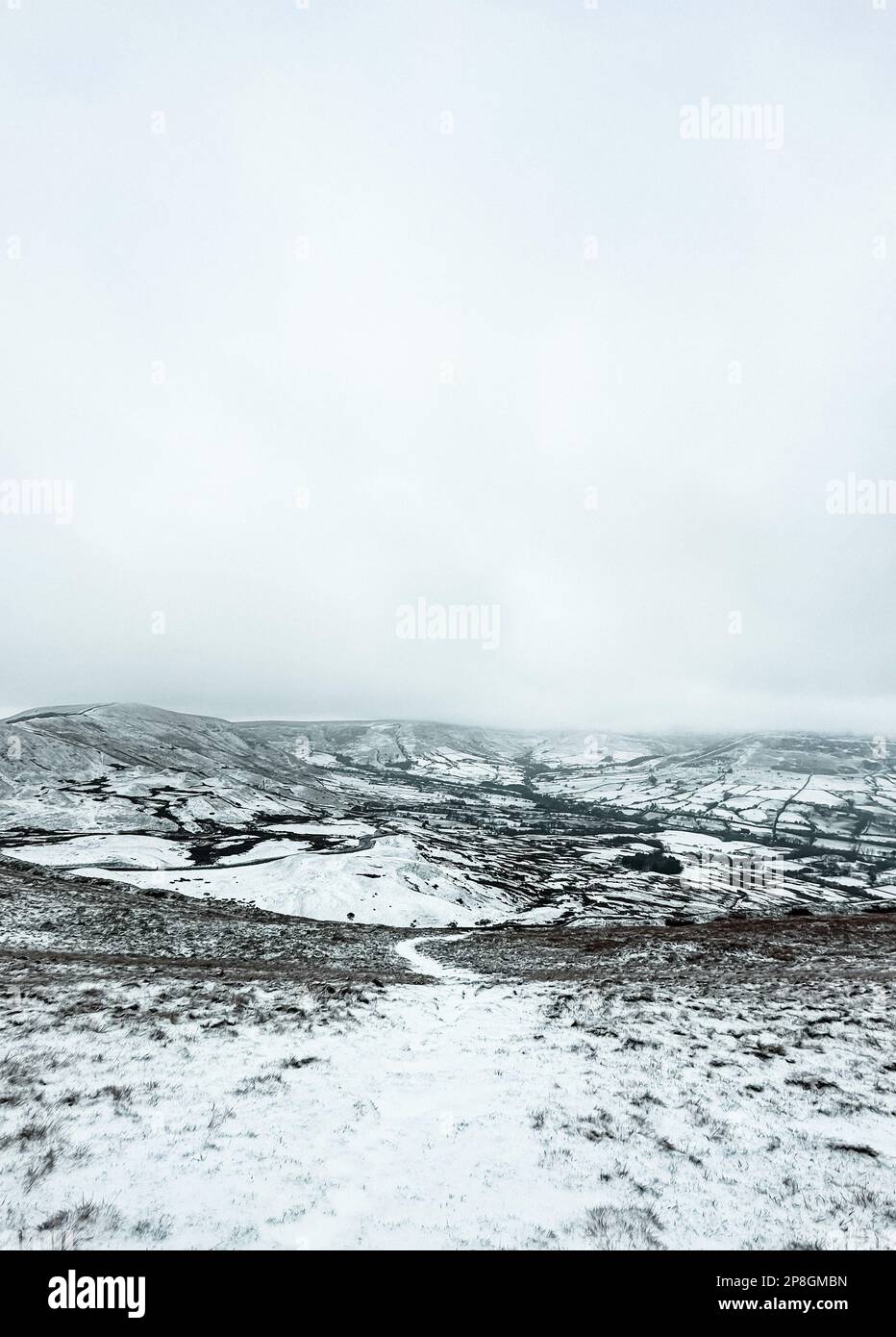 Schneebedeckte felsige Berge auf dem Gipfel des Mam Tor, Peak District an einem bewölkten Tag Stockfoto