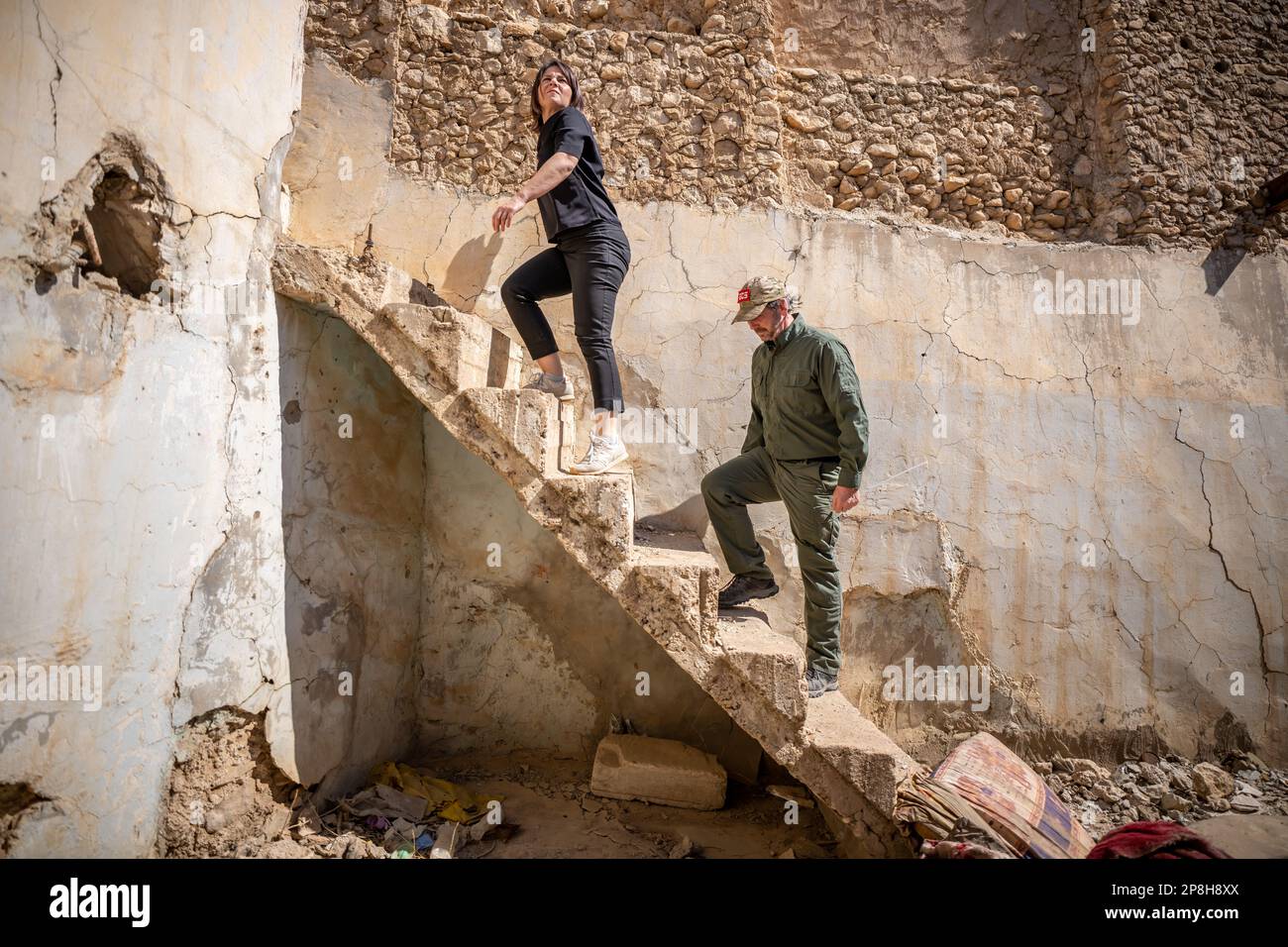 Sindschar, Irak. 09. März 2023. Annalena Baerbock (Bündnis 90/die Grünen, l), Außenministerin, und die für die Minenräumung zuständige Person, Ian Johnston von Global Clearance Solutions, besuchen das zerstörte Stadtzentrum von Sinjar. Während ihrer Reise besucht Baerbock die nordirakische Stadt Sinjar, die wichtigste Siedlungsregion der Yazidis. Der Islamische Staat gilt als verantwortlich für den Völkermord an den Yazidis nach 2014. Kredit: Michael Kappeler/dpa/Alamy Live News Stockfoto