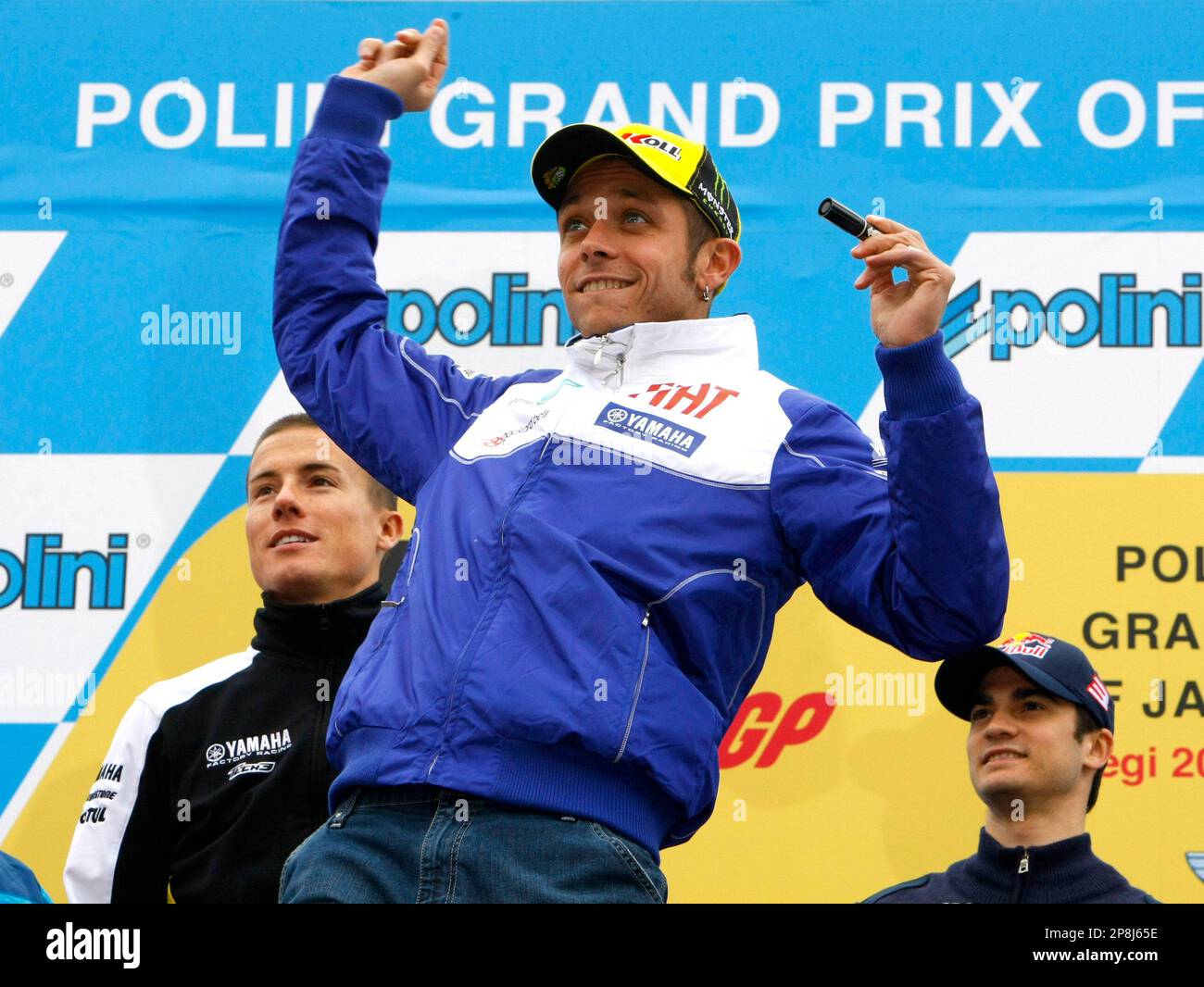 Italy's MotoGP rider Valentino Rossi, center, throws a cap he wrote his autograph on during an event for fans ahead of Sunday's Japanese motorcycling Grand Prix at Twin Ring Motegi circuit, north of Tokyo, Friday, April 24, 2009. At right is Spanish rider Dani Pedrosa and at left is British rider James Toseland. (AP Photo/Shizuo Kambayashi) Stockfoto