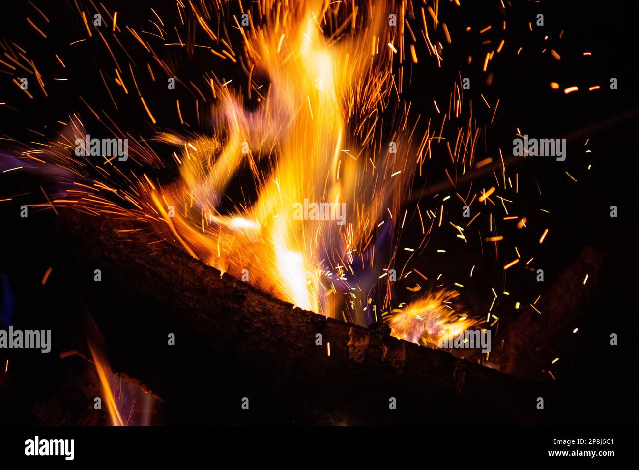 Funken fliegen von einem brennenden Holzfeuer Stockfoto