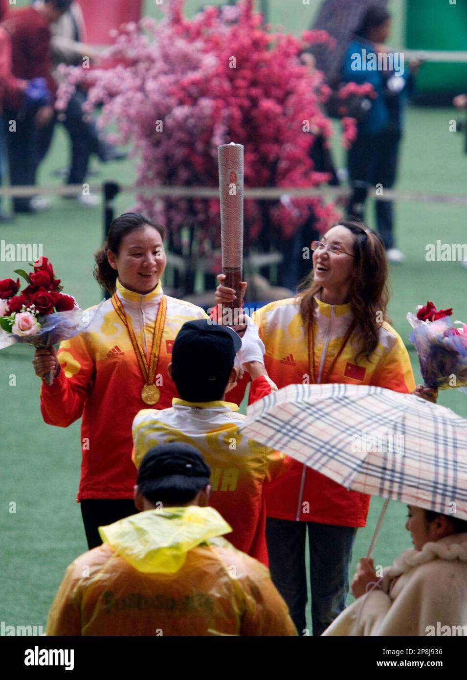 Chinese tourists wearing fake gold medals and holding a real Olympic
